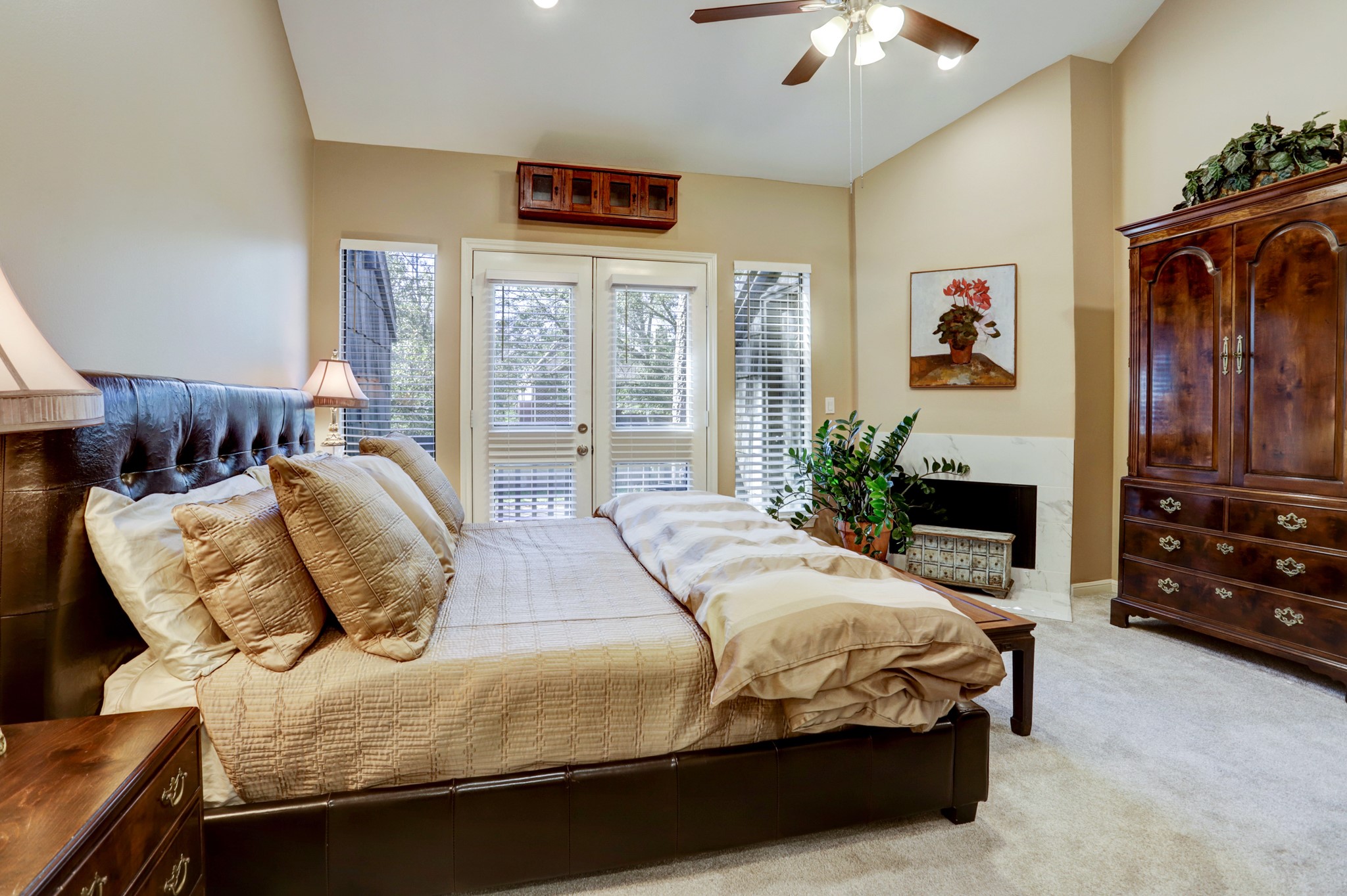 Primary bedroom w/ vaulted ceilings, fireplace and private balcony