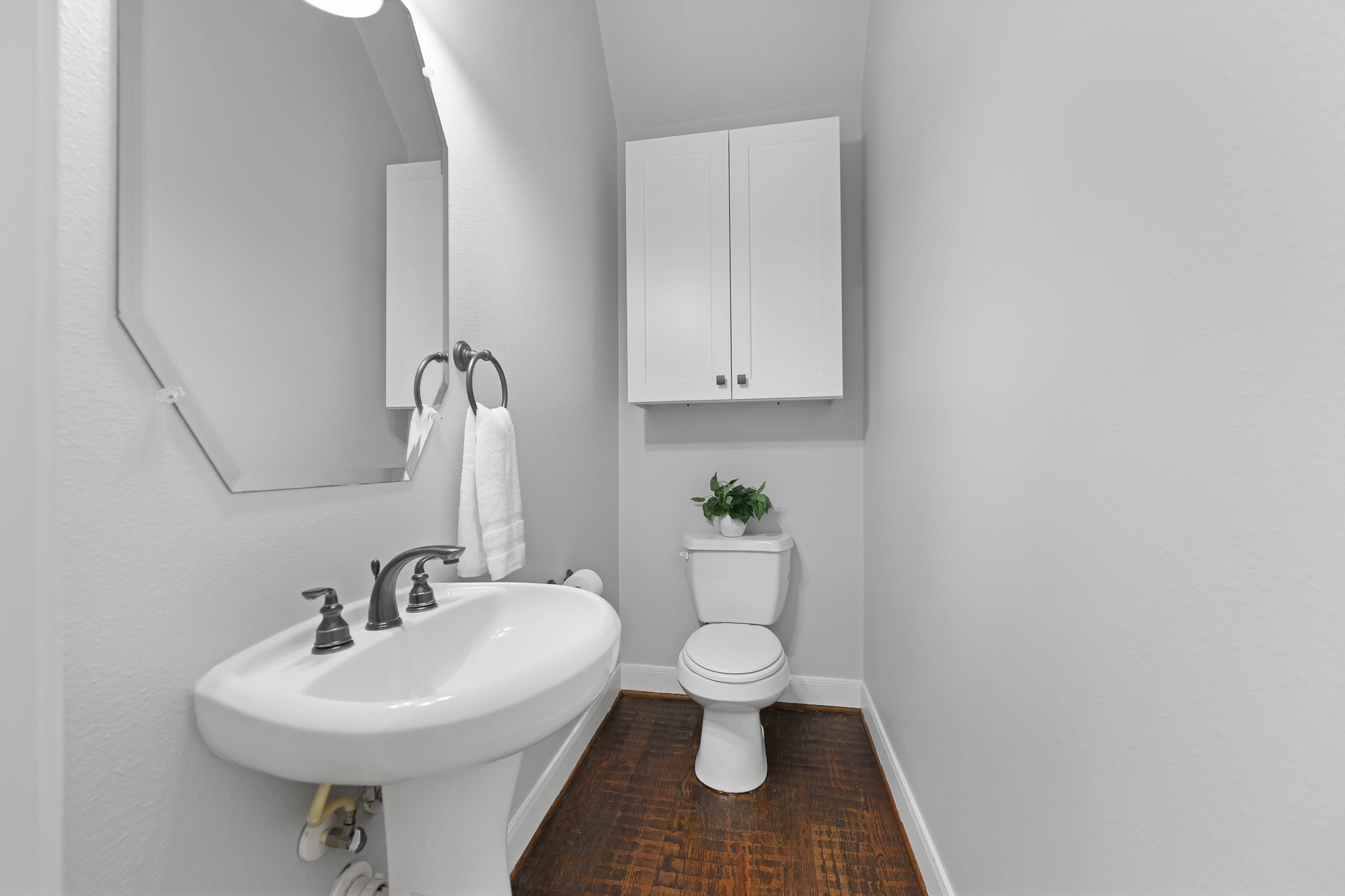 THE POWDER ROOM IS PERFECT FOR GUESTS WITH PEDESTAL SINK AND USEFUL ADDITIONAL CABINETS.