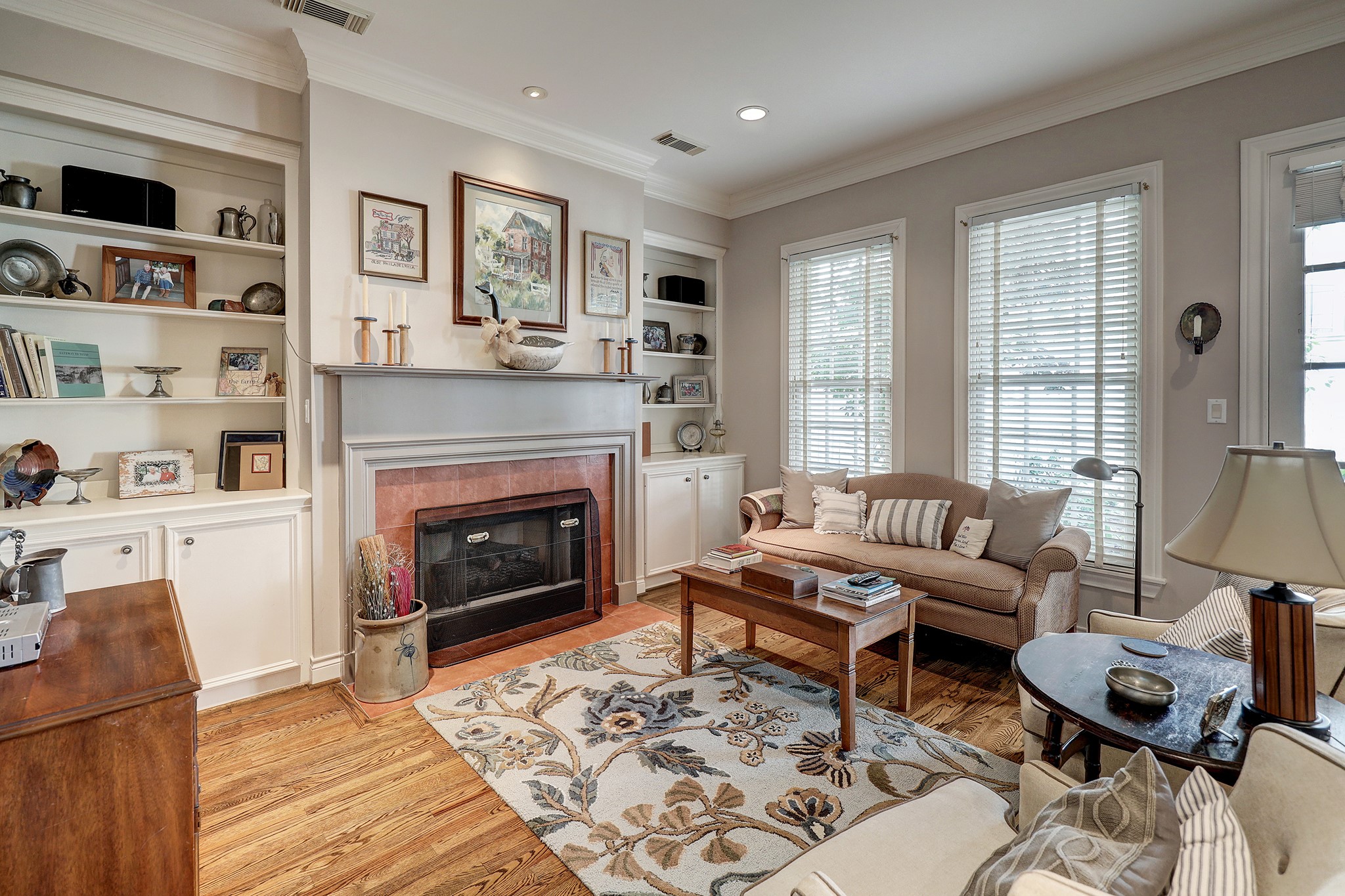 This cozy family room has a gas log fireplace with a beautiful mantel and is completely connected to the kitchen.