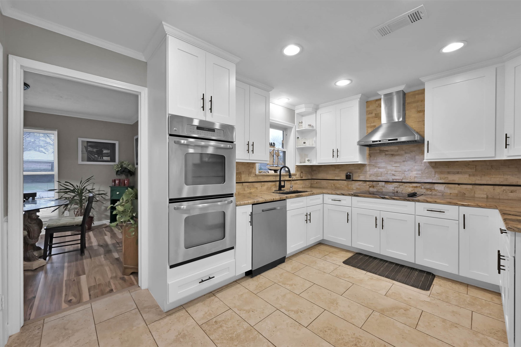The kitchen has been completely remodeled with shaker style cabinets with soft close drawers and hardware. The tile is rectangular and set in a brick pattern.