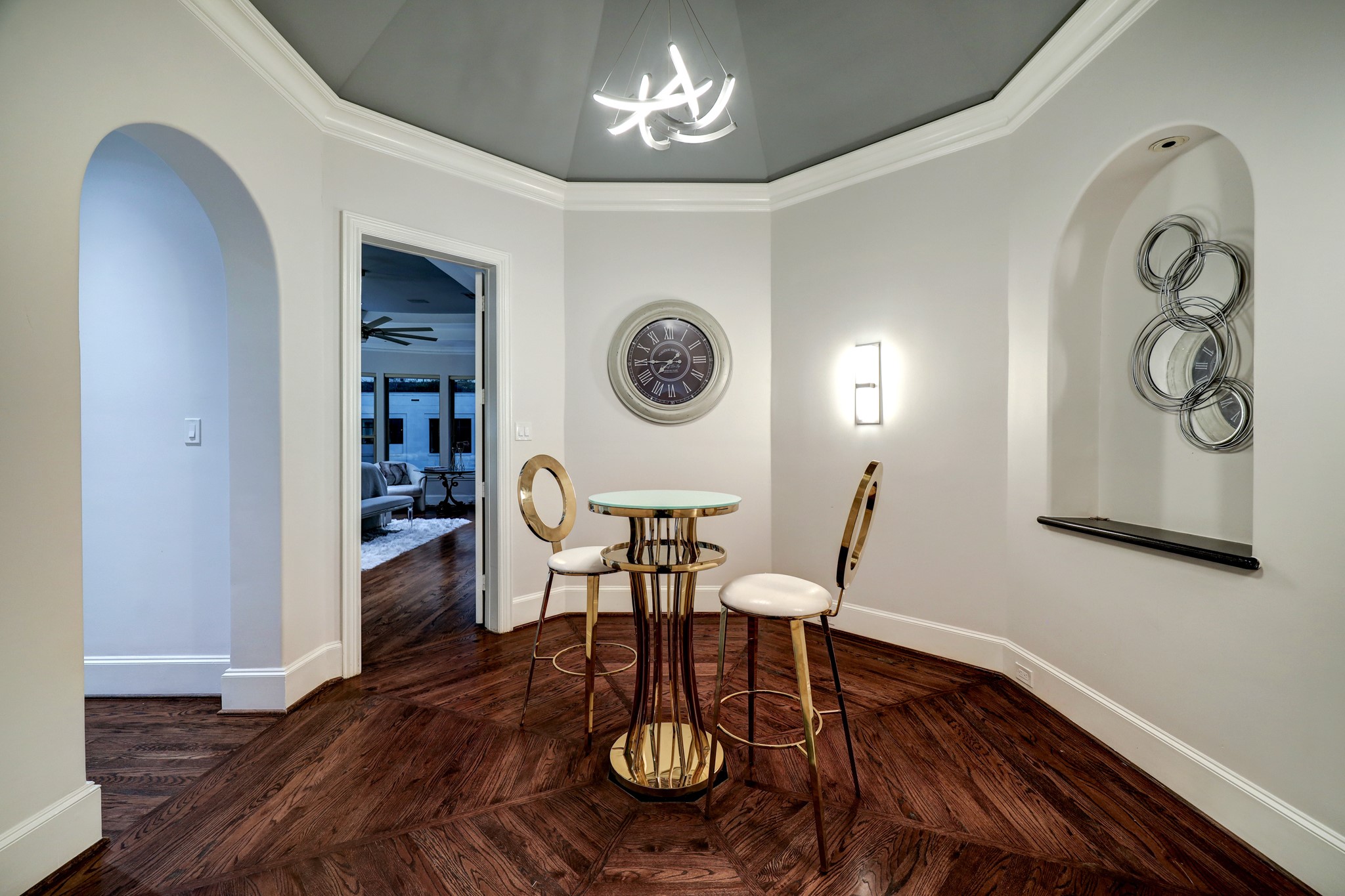 The Primary Vestibule features octagonally laid hardwood floors, octagonally domed ceiling, lit art niches, and crown molding & baseboards.