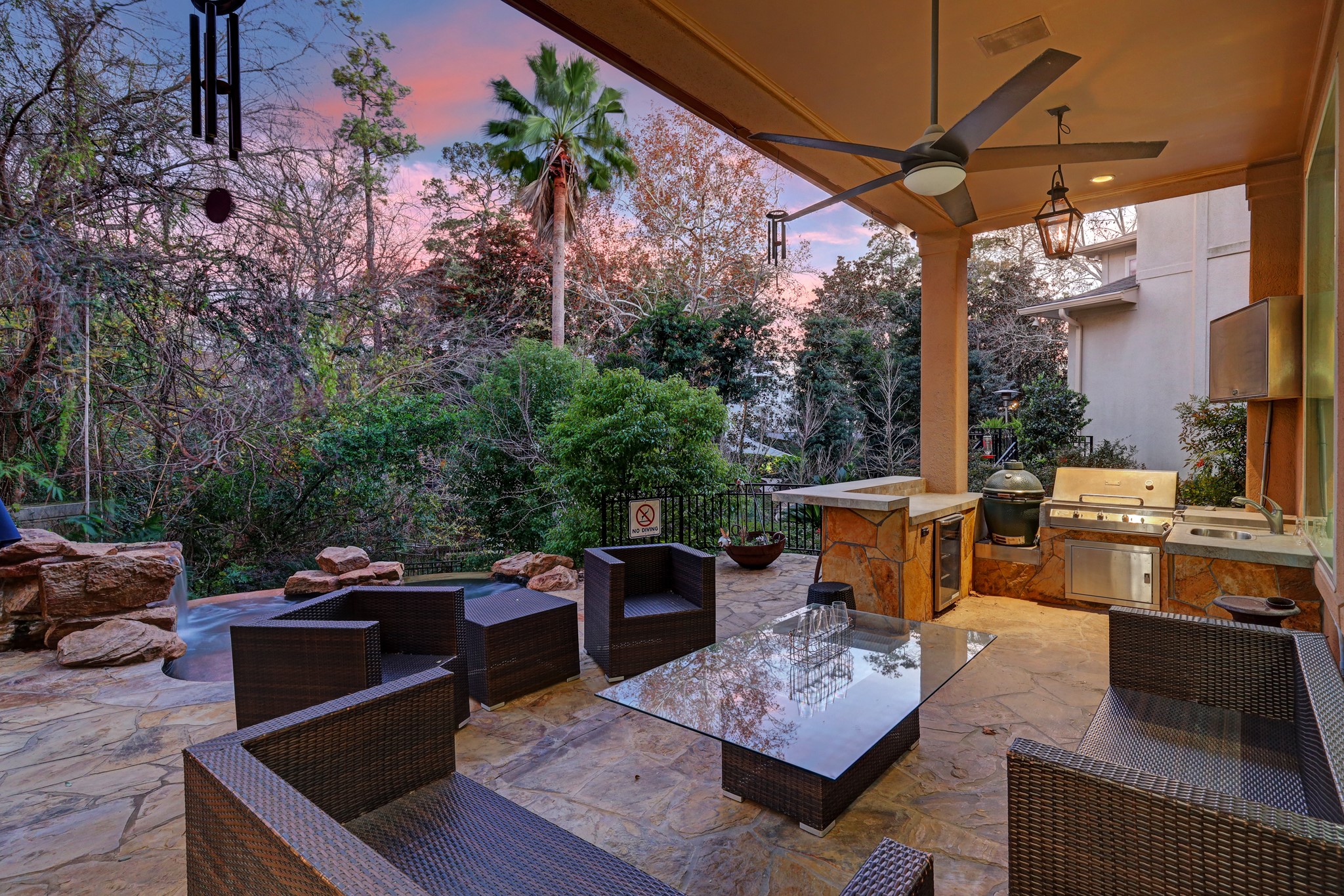 The Backyard Oasis features a covered patio/summer kitchen with grill, Green Egg and TV, plunge pool/hot tub, expansive decking and meandering terraces surrounded by lush landscaping.