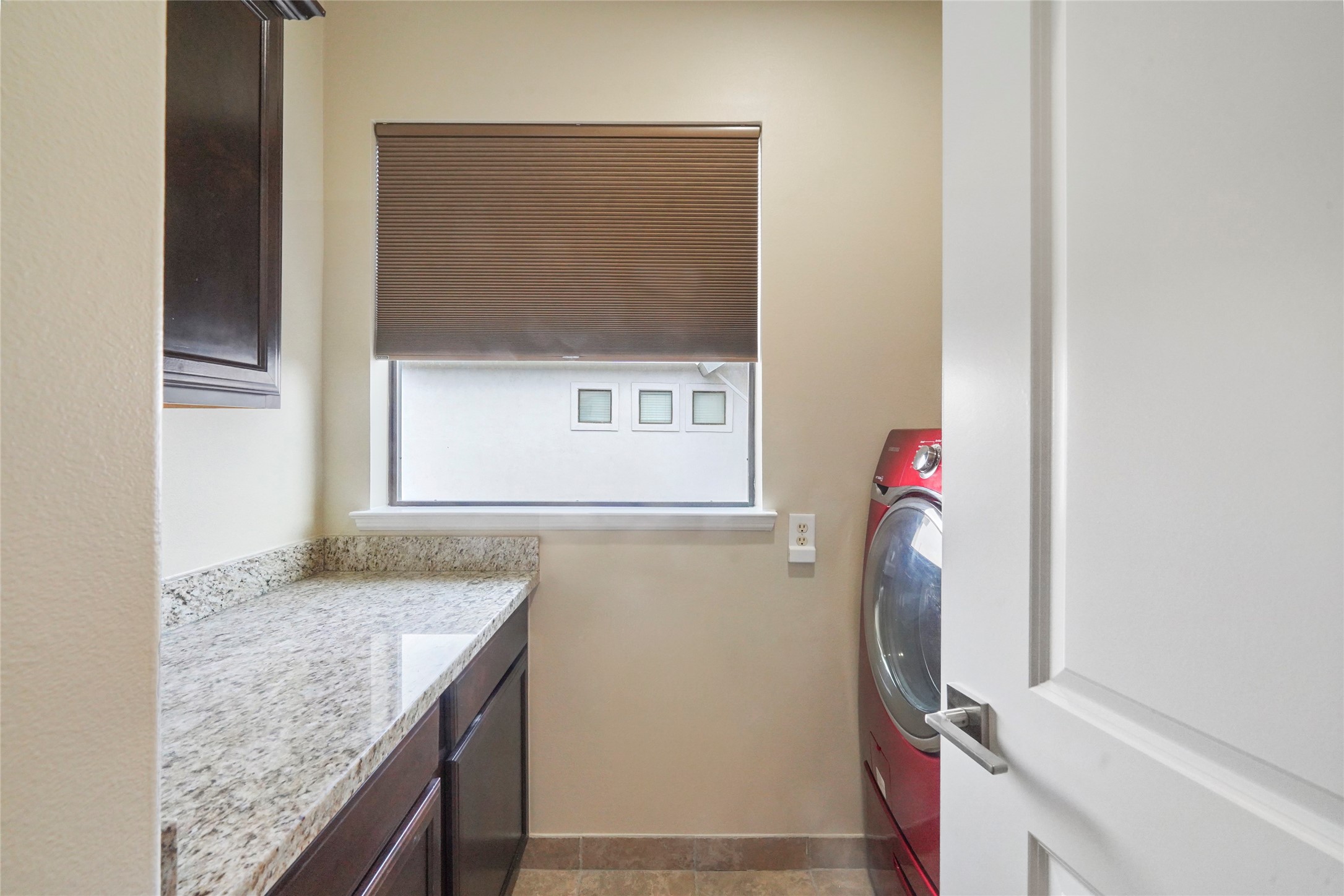 Walk-in laundry room with upper and lower storage.