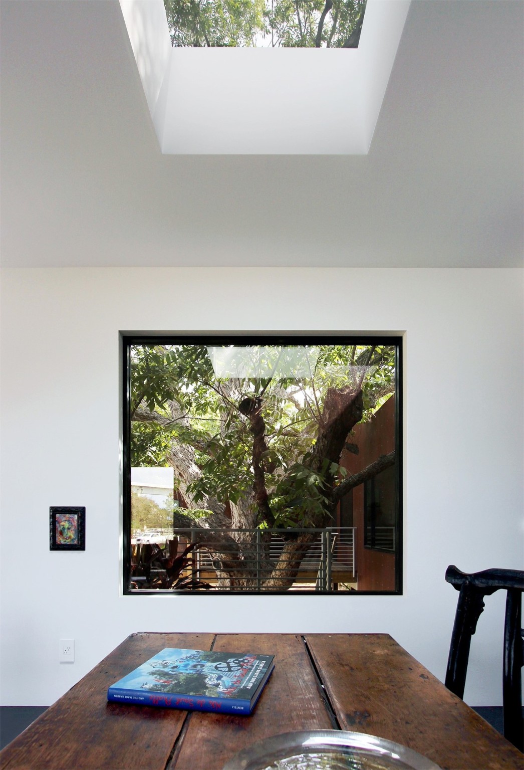 The tree is the focal point for the dining area, arching overhead and seen through a large skylight above.