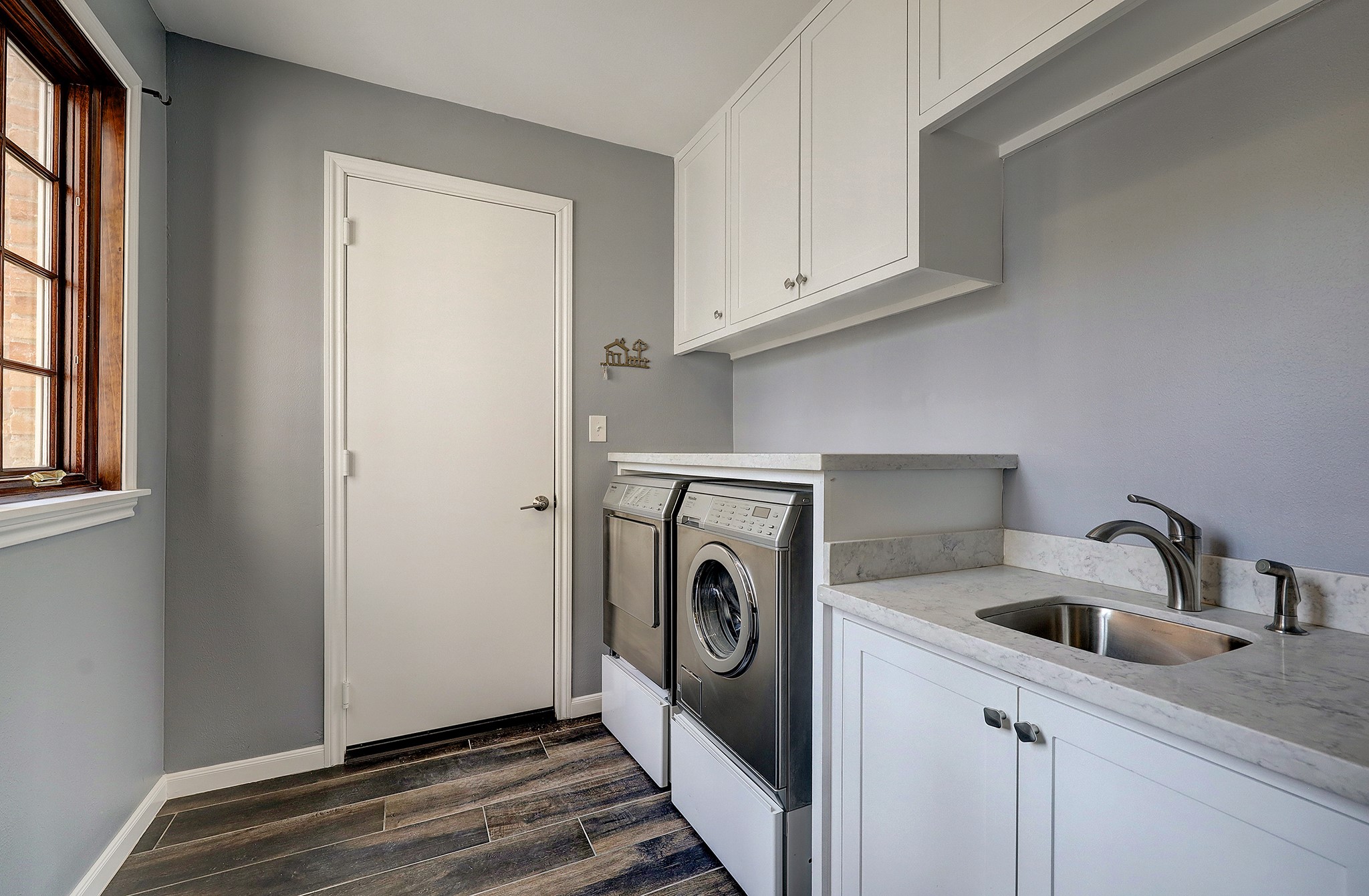 Have fun doing your laundry is this utility room with a sink, window and folding table counter top.