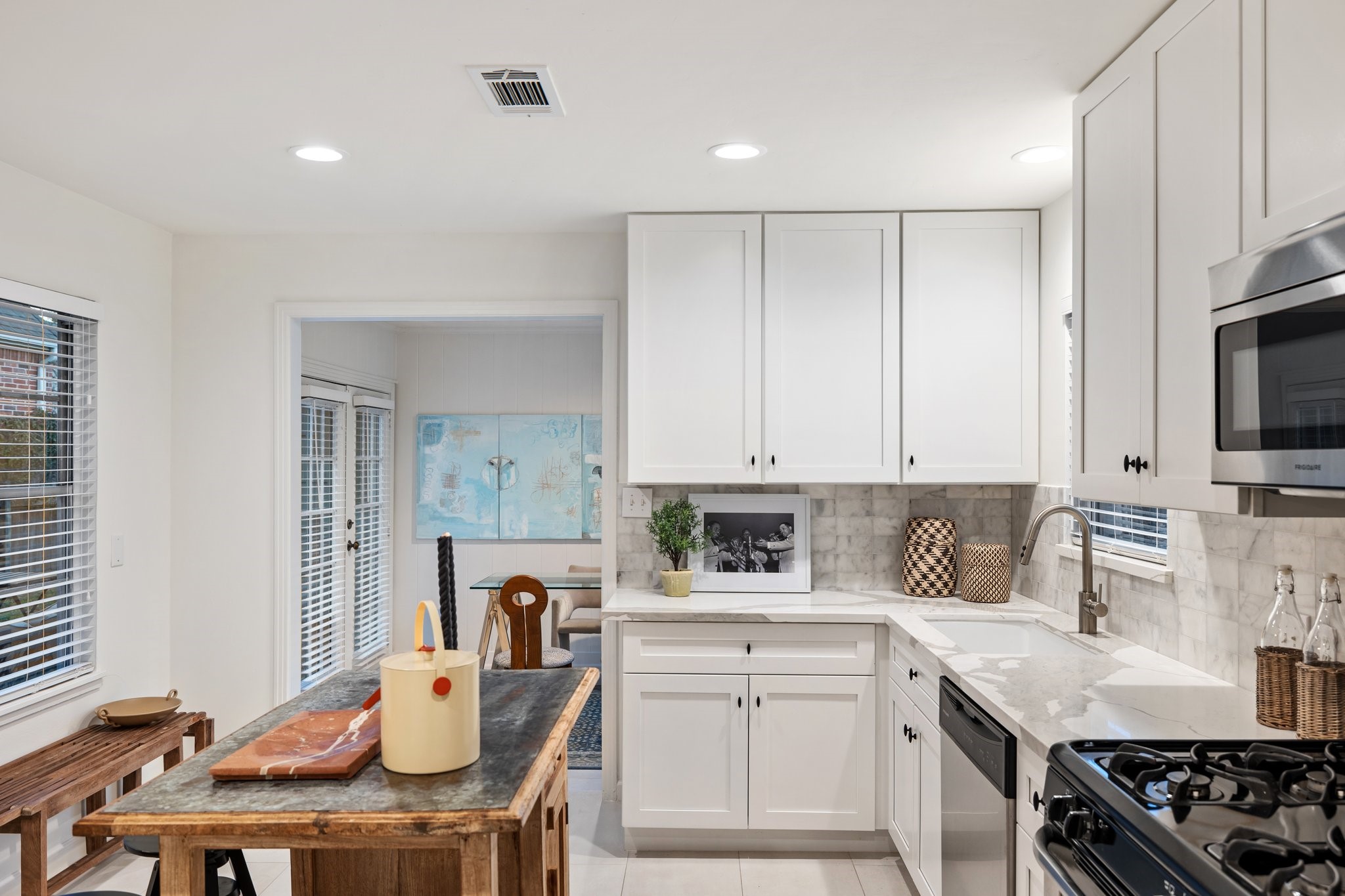 Newly remodeled kitchen boasts silestone countertops, marble backsplash, custom cabinets, sink, faucet, and tasteful tile flooring.
