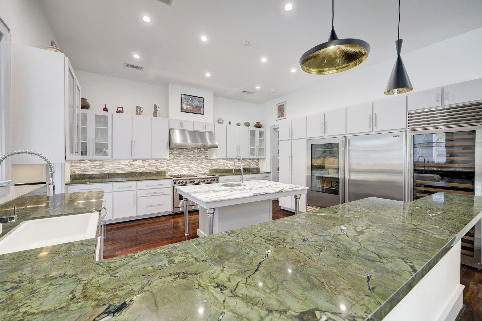 The island kitchen is equipped for entertaining with 48” wolf range with 6 gas burner, griddle and two ovens, 2 sinks, huge glass-front Sub-Zero refrigerator and freezer and a large wine refrigerator! You can seat at least four people at the breakfast bar. Gorgeous marble counters!