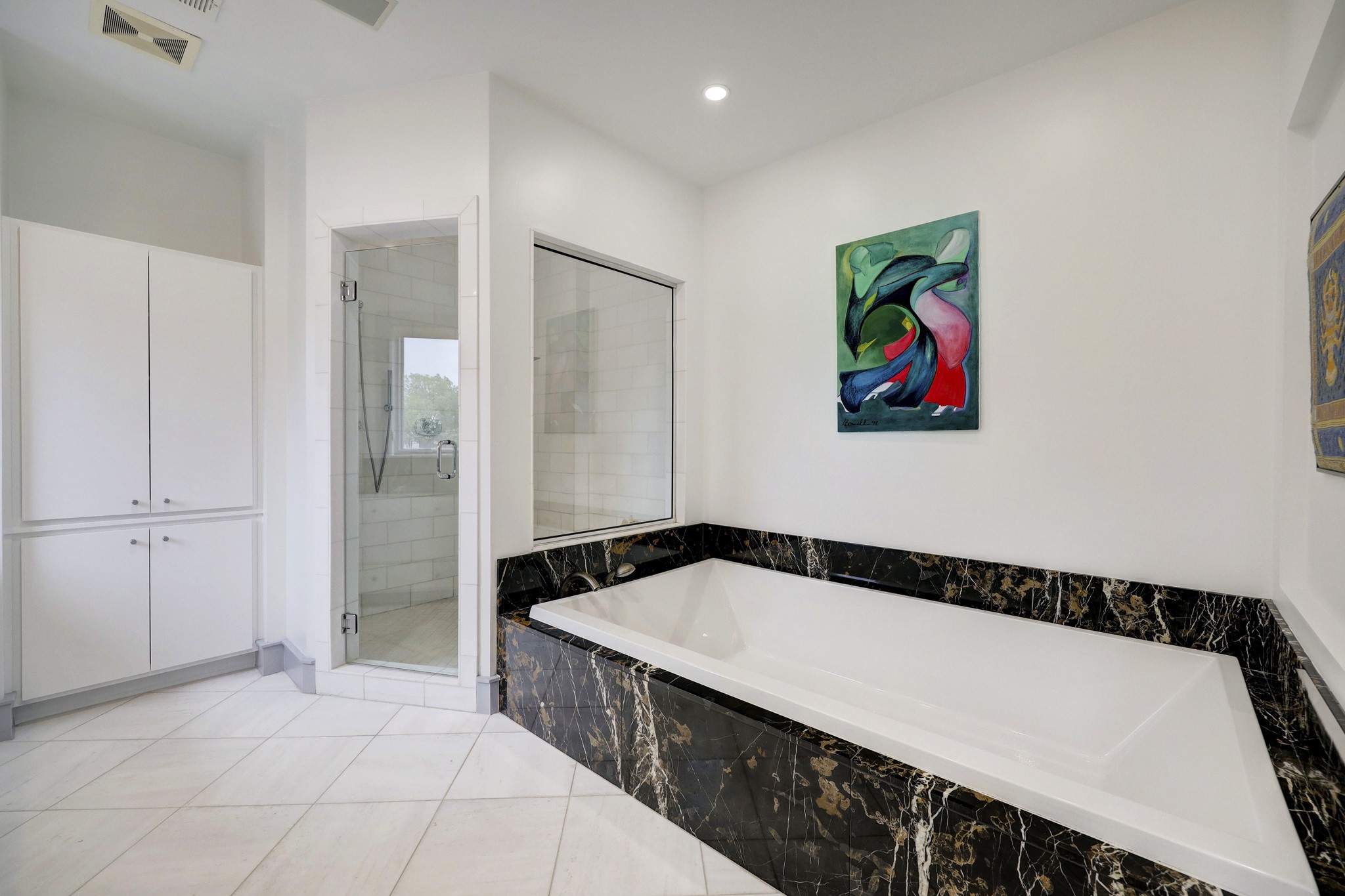 Bold marble accent pieces surround the relaxing soaking tub.