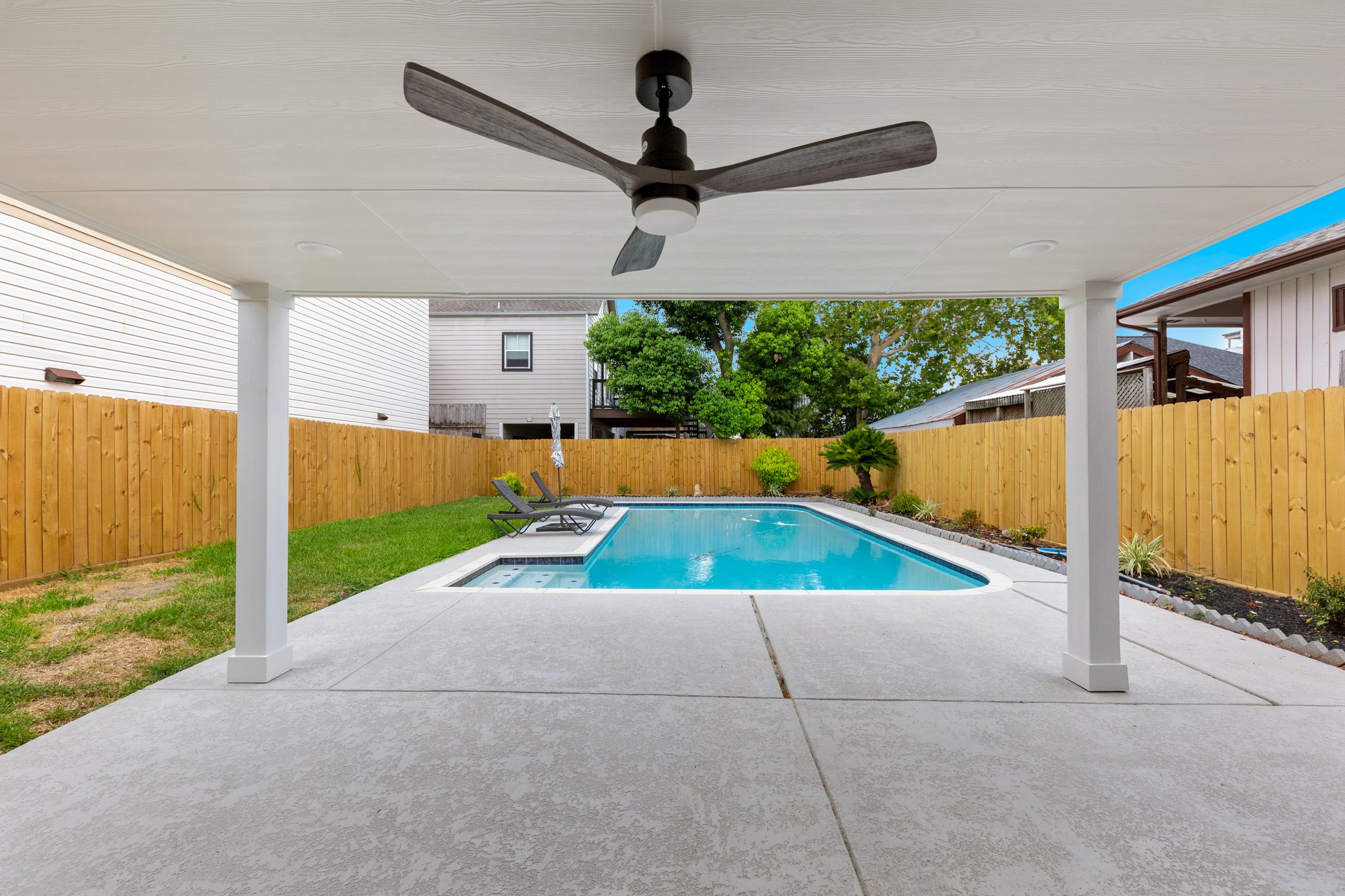 Covered back patio perfect for comfy patio furniture overlooking sparkling pool