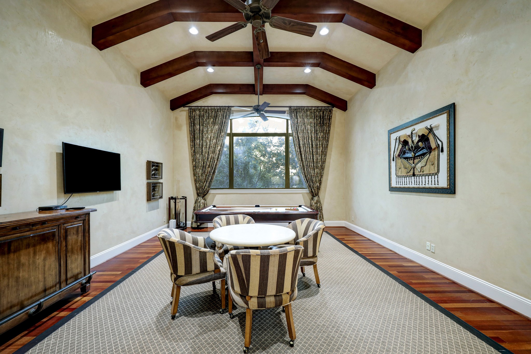The Game Room [21 x 18] is located on the second floor and features hardwood floors, baseboards, a raised and beamed ceiling and Segretto walls.