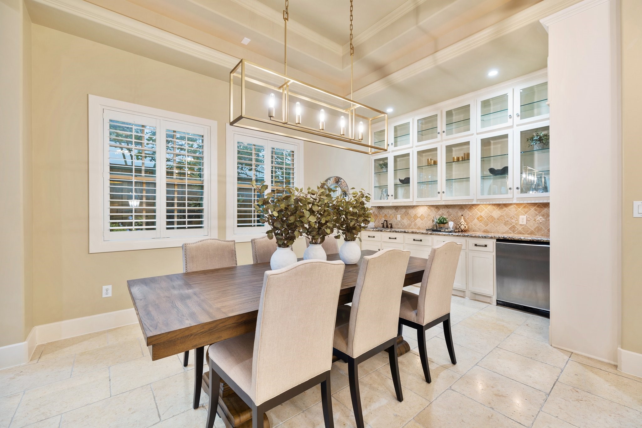 DINING - Dining room features tray ceiling with cove lighting, plantation shutters, and custom light fixture.