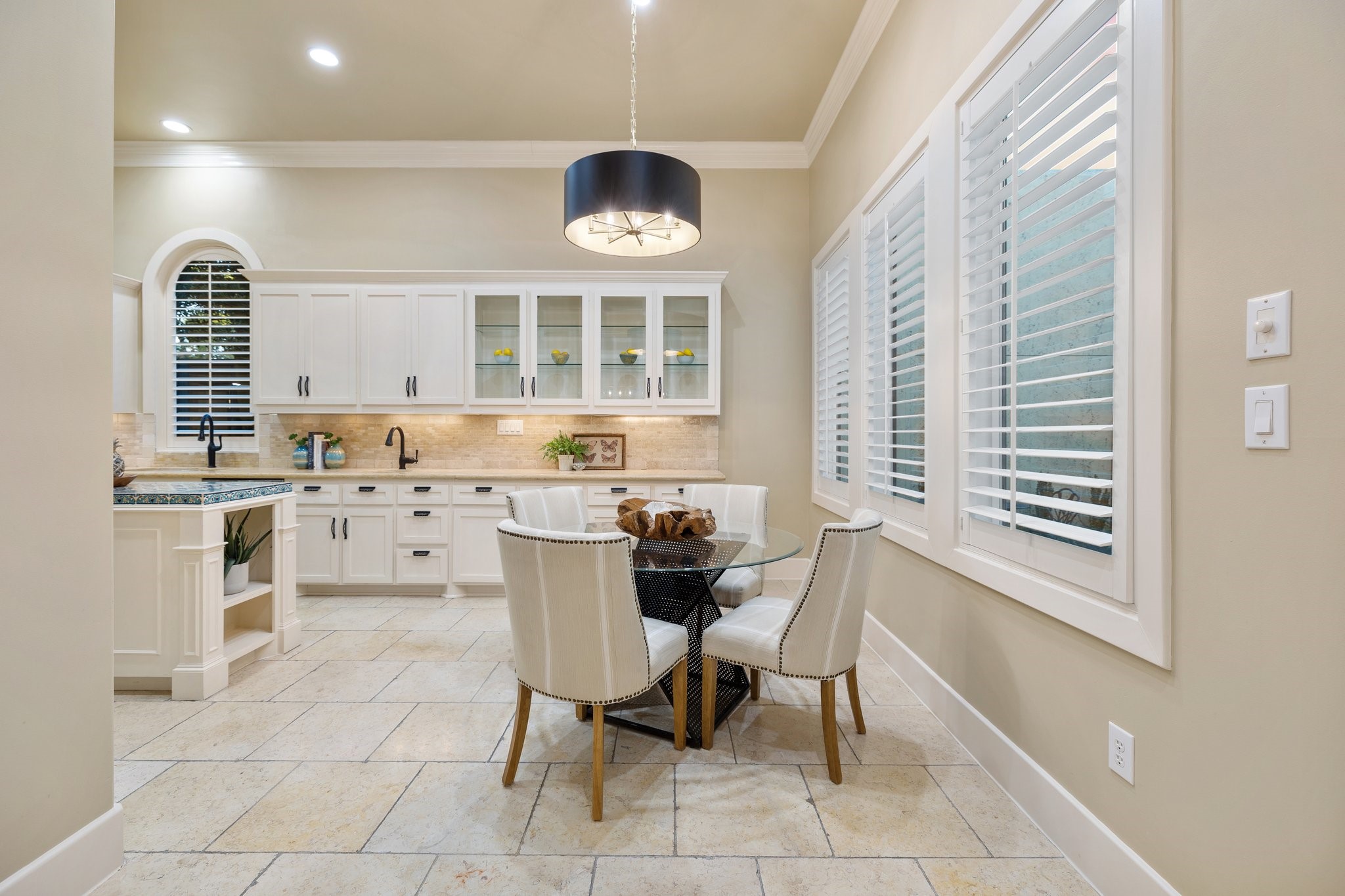 BREAKFAST - Breakfast area with custom light fixture and wall of windows with plantation shutters.