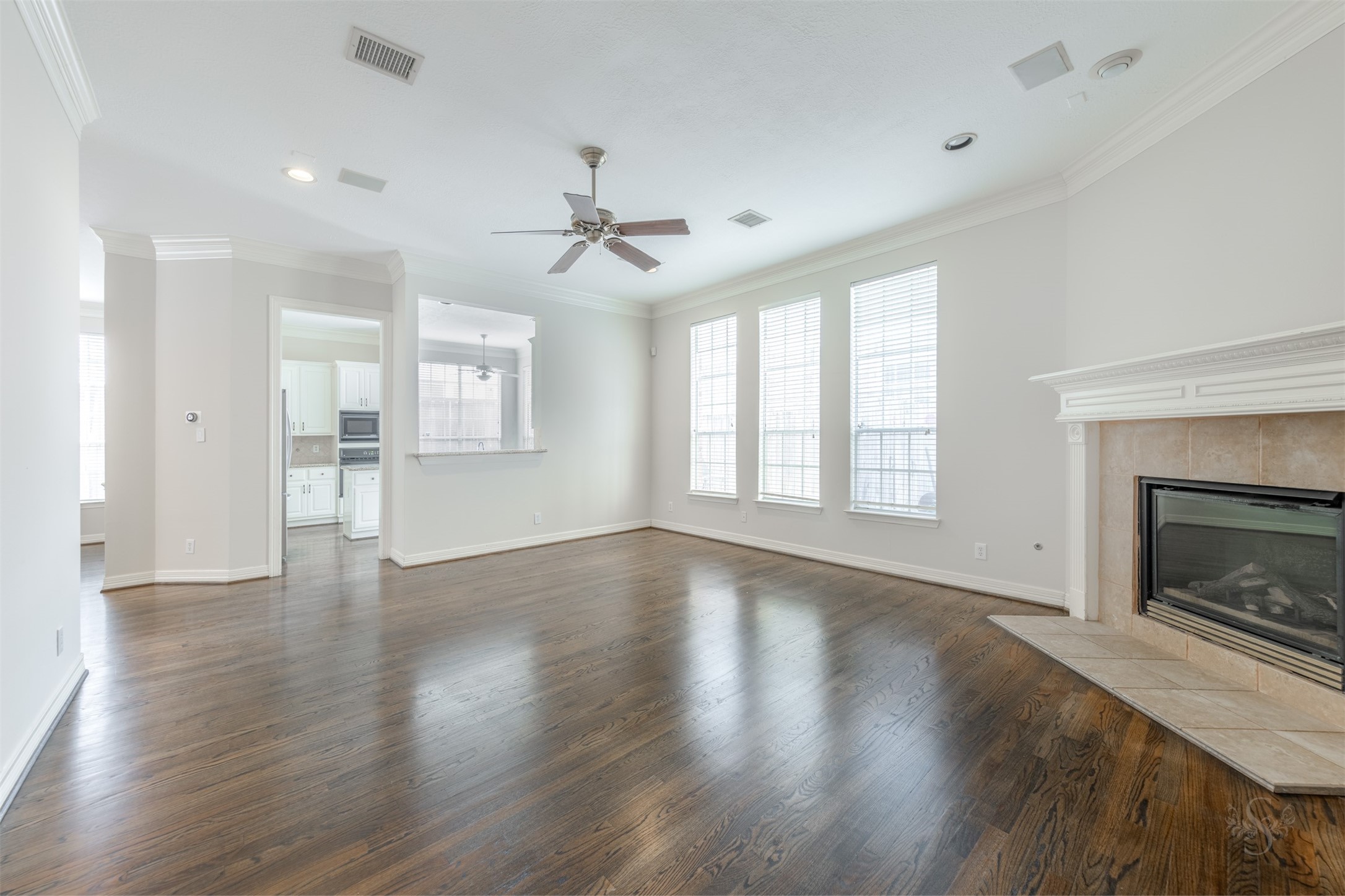 This inviting family room provides a lovely gathering place for your family and friends! Featuring high ceilings, wood flooring, fireplace & mantel and wall of windows bringing in lots of natural light!
