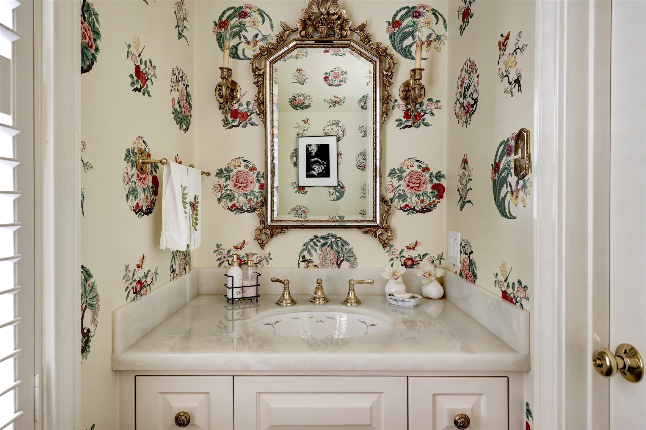 An elegantly appointed downstairs powder bathroom echoes the luxury of the adjoining spaces.