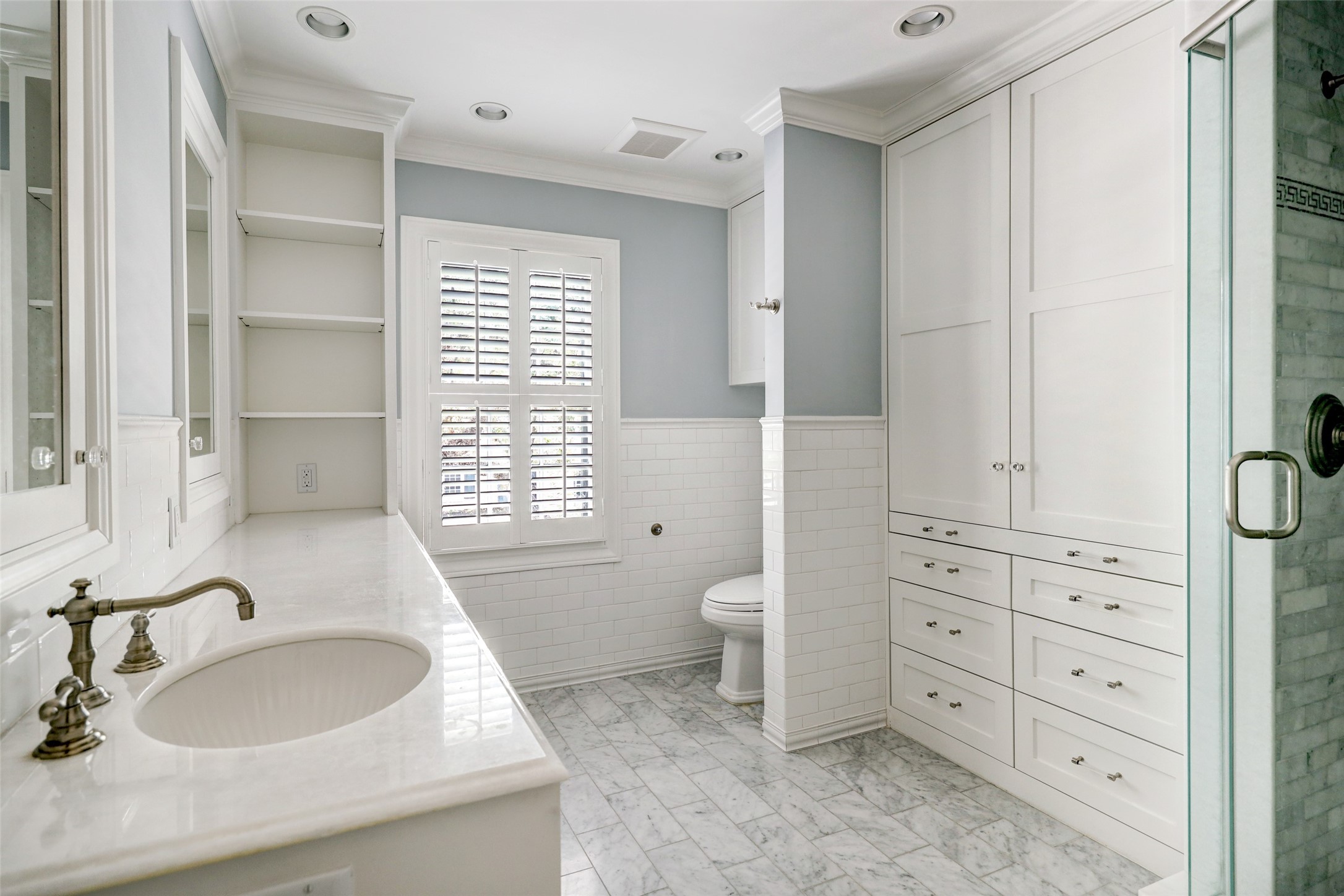 The gorgeous en-suite bathroom is a true sanctuary, offering an abundance of storage and counter space and a beautiful walk-in shower, featuring a comfortable bench for relaxation and a spa-like experience.