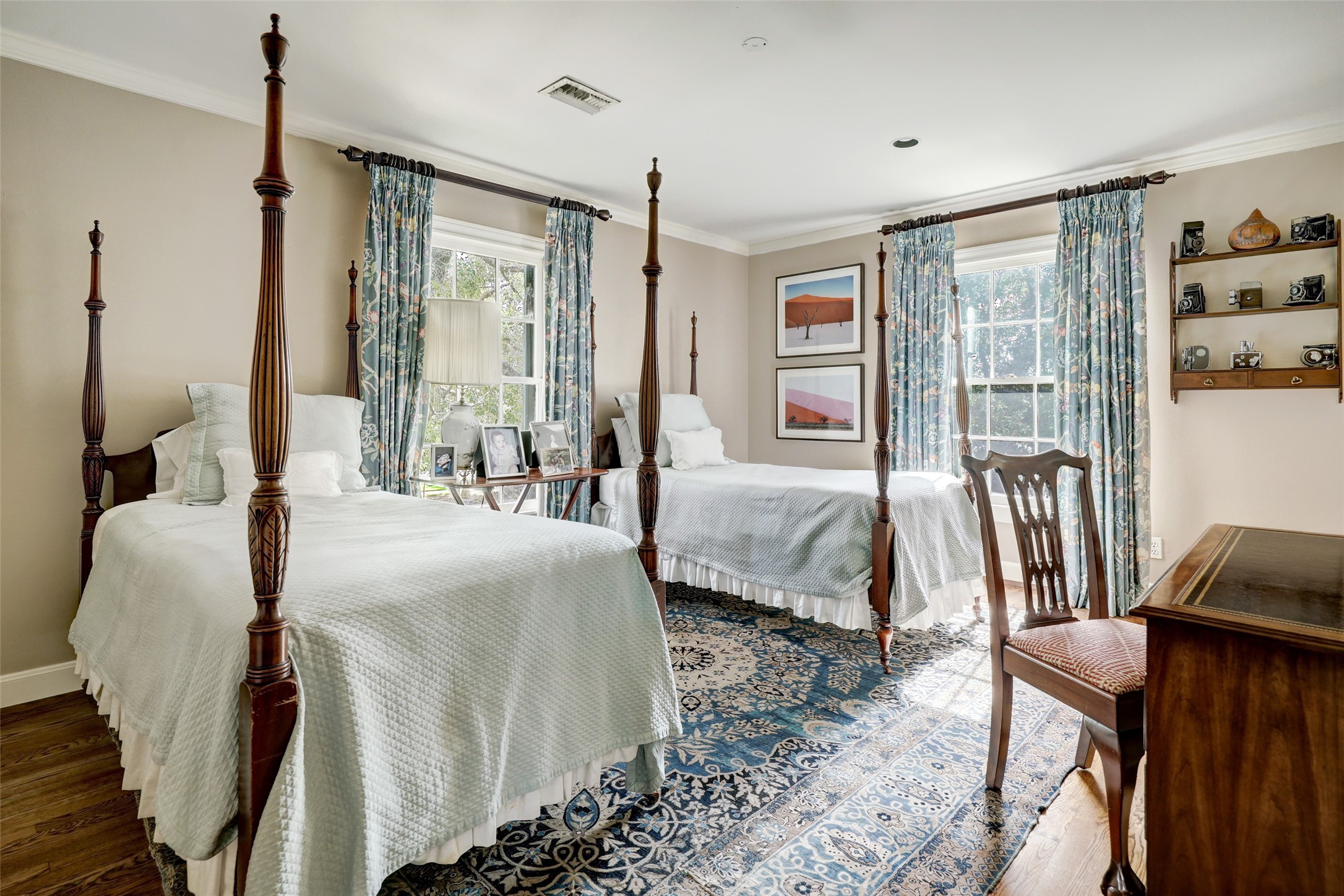 This secondary bedroom offers a comfortable and stylish retreat, where the combination of the handsome hardwood floors and flood of natural light creates a harmonious and visually pleasing environment.