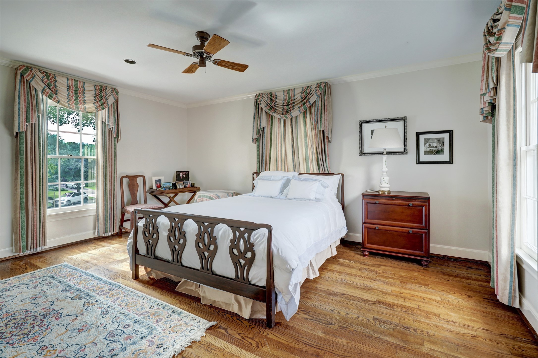 Rich hardwood floors and large windows enhance the aesthetic appeal of the fourth bedroom.