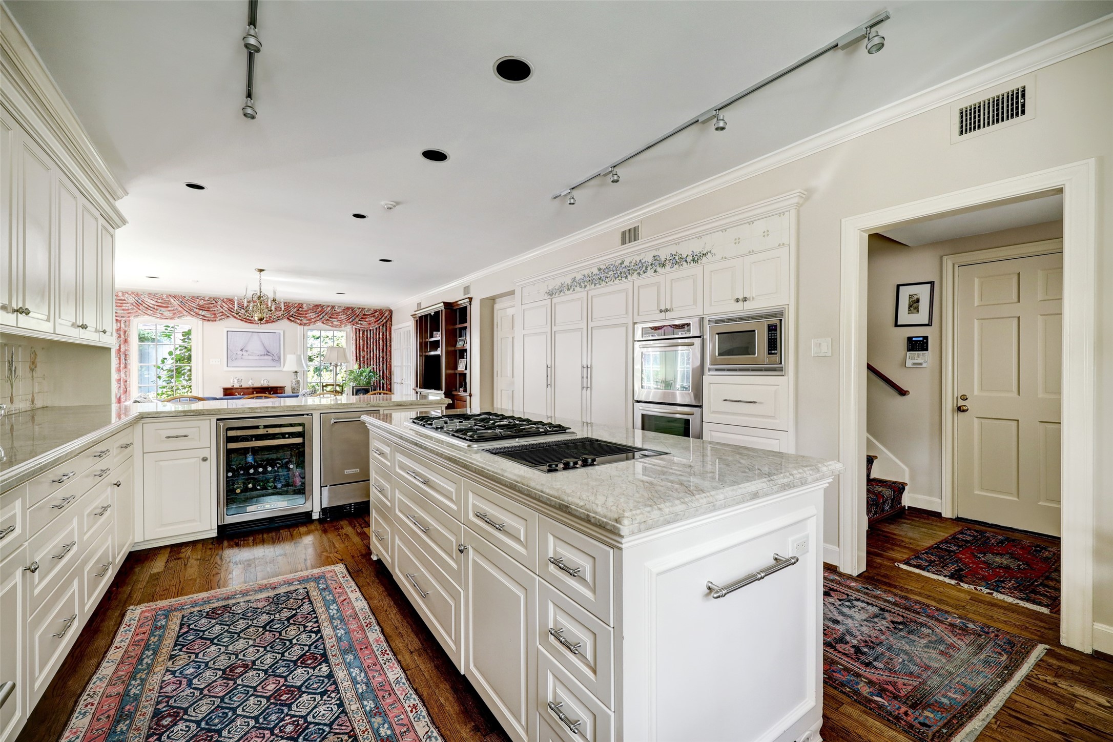 The kitchen is a culinary haven with ample storage options, a breakfast bar that gracefully separates the kitchen from the den and gleaming hardwood floors that flow seamlessly throughout the entire first floor.