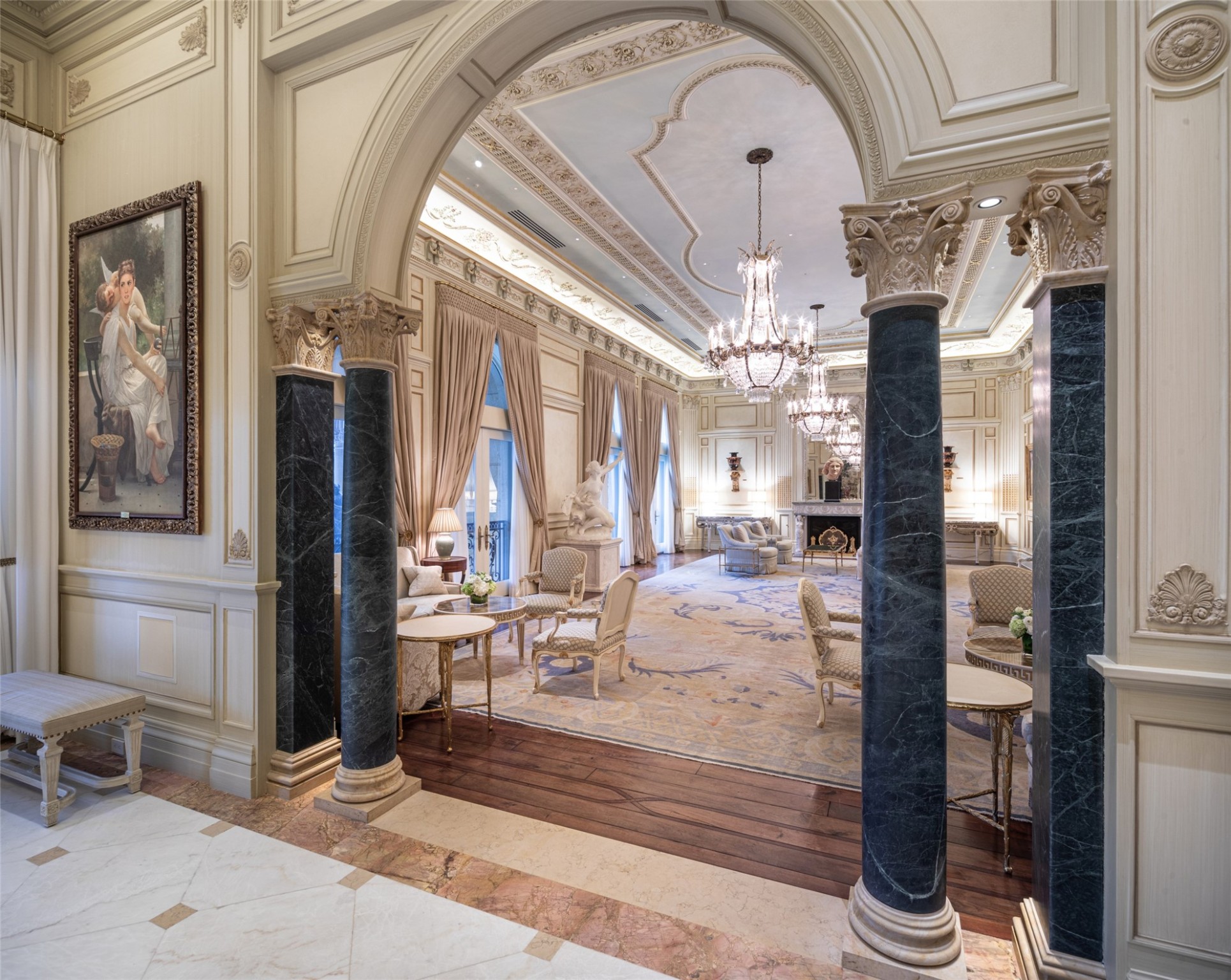 Marble columns with Corinthian columns flank the entryway to the Versailles room, an otherworldly retreat crafted with the utmost attention to historical detail and master craftsmanship, inspired by the grand salons of the renowned French palace.