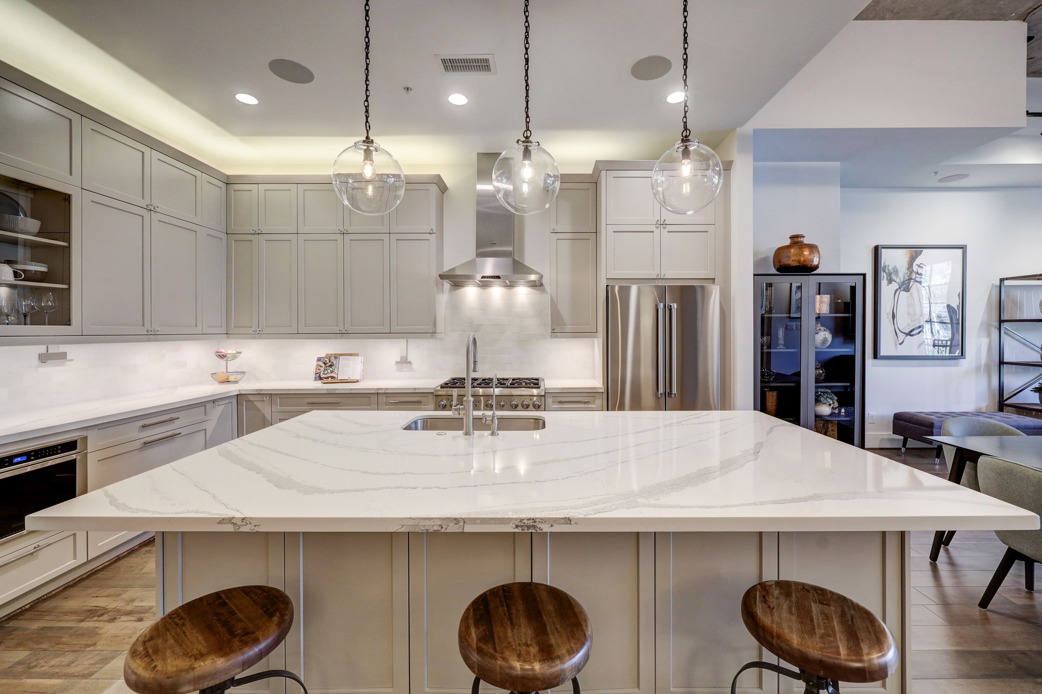Cook your favorite meals in this chef inspired kitchen. The kitchen features Cambria quartz countertop, stylish pendants, and Thermador appliances including a professional gas range, stainless-steel vent hood, microwave and dishwasher plus a Bosch refrigerator.