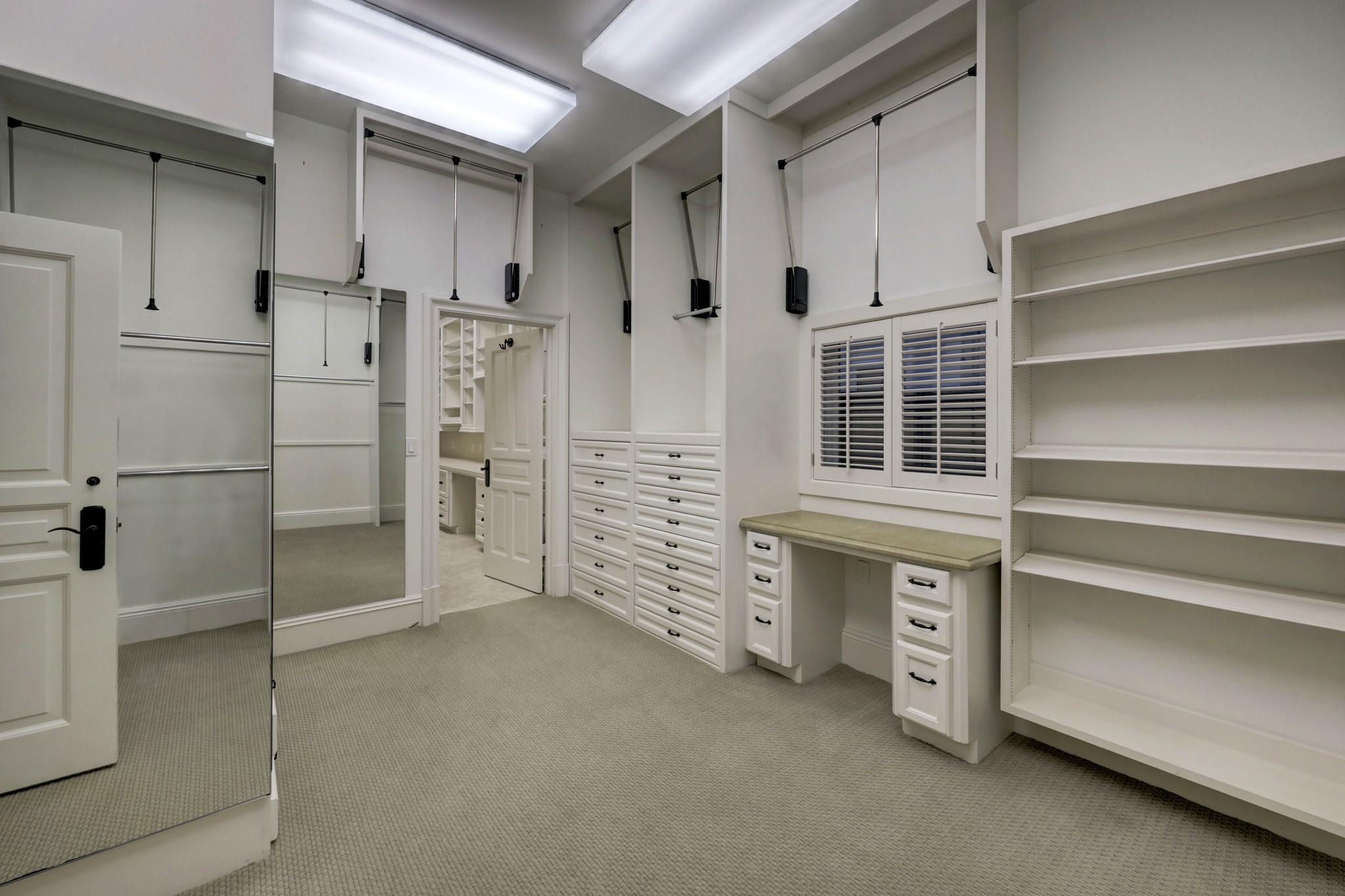 WOWZA!  Now THIS is a closet!  There are single, double and triple hanging rods with pull down capability, make-up vanity, full length mirror, ample shelves and access to the private home office between the two Primary closets.  Amazing storage.