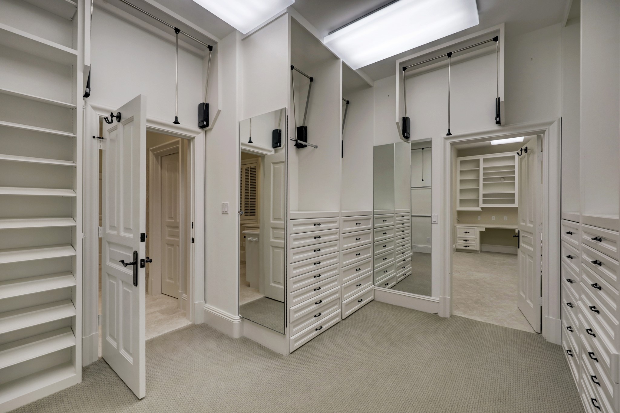 Another view of one of the Primary closets.  Ample drawers and shelves plus single, double and triple hanging rods.  The vanity is out of view to the right of the image.  This large closet is located between one of the dual baths and the private office.