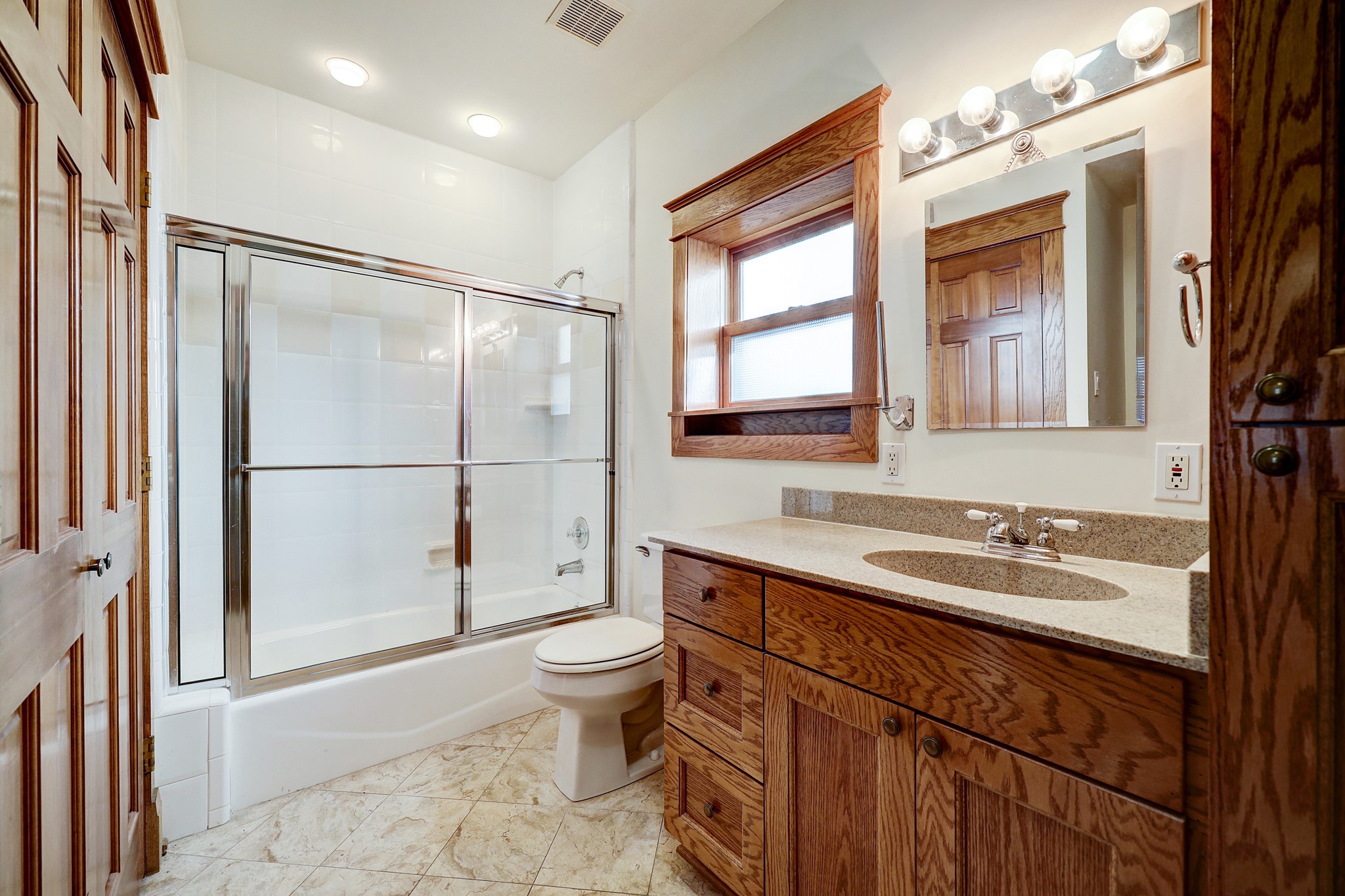 A full bathroom is situated downstairs and is ideally located for guest use yet private from living spaces. Featuring an oversized mirror vanity, granite countertops, and custom cabinetry.