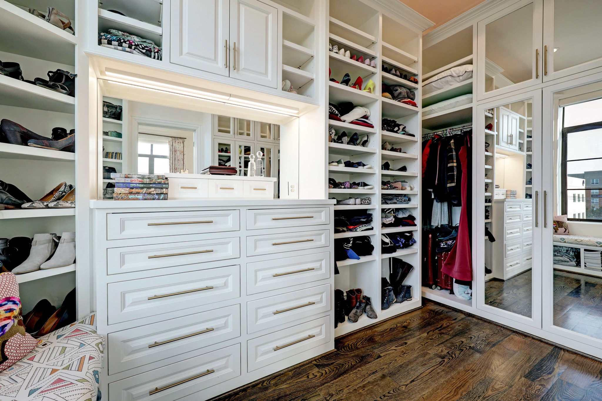 Amazing primary closet with mirrored wardrobes.