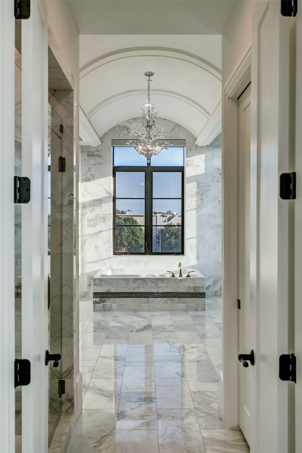 Primary bath boasts a barrel ceiling and designer light fixtures.