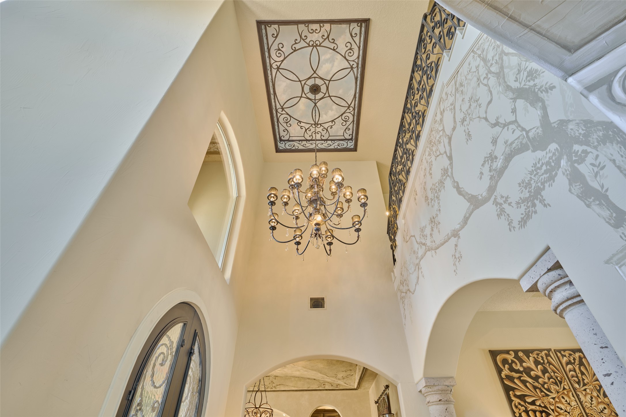 Custom painted foyer with grand chandelier.  Special feature of this lighting is a second-floor motorized control that lowers the chandelier for changing the bulbs or cleaning.