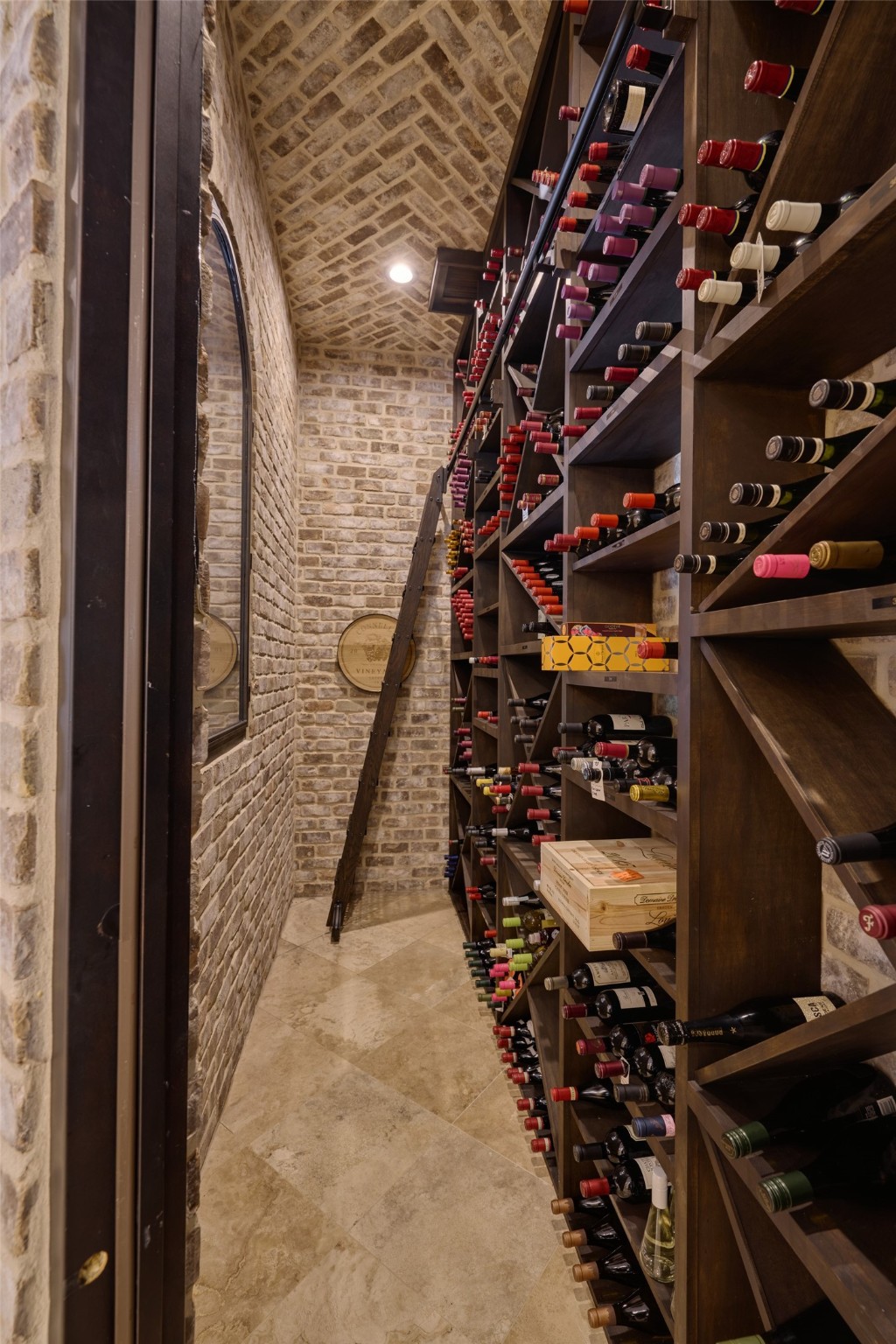 Over 100 cases of wine can fit in this true wine cellar, temperature-controlled at 57 degrees, a ladder for the higher shelves, travertine marble flooring, and brick walls.  A wine lovers dream come true.  Wine is not included in the sale of this home.