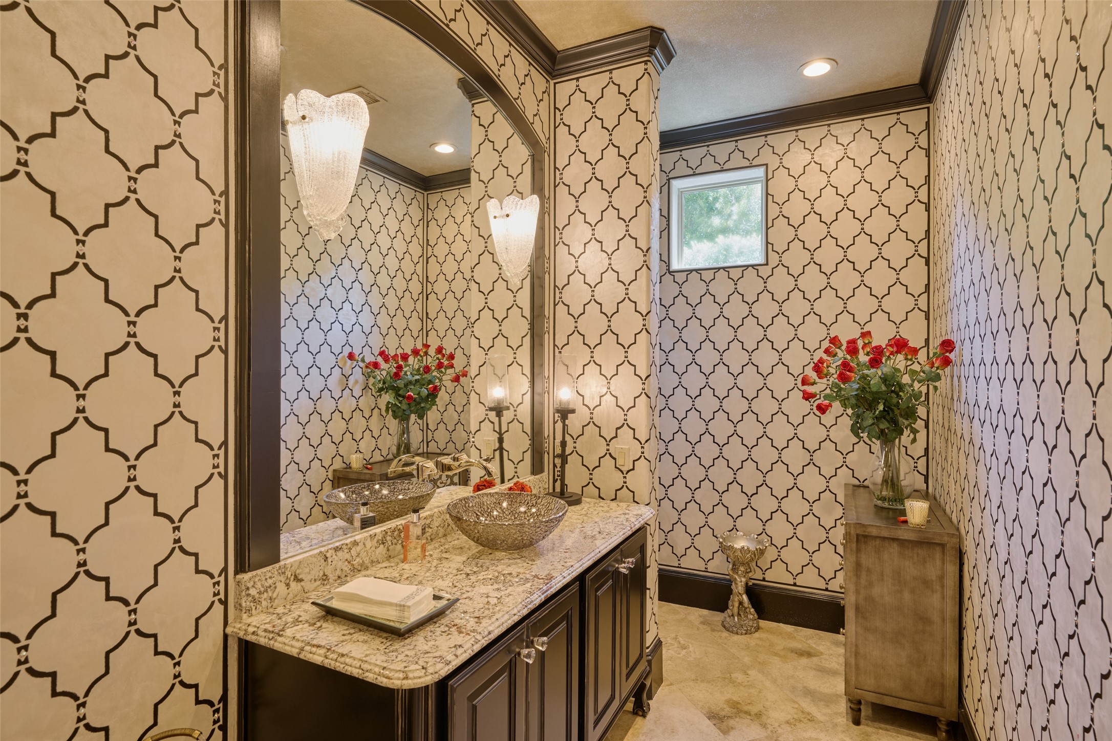 Guest bath on first floor with high-end luxury jeweled wallpaper greets your guest with sheer sophistication.  Located just off the kitchen near the breakfast area/coffee bar.  Black crown molding, black custom vanity and black toilet... this is the bathroom your guests will remember!
