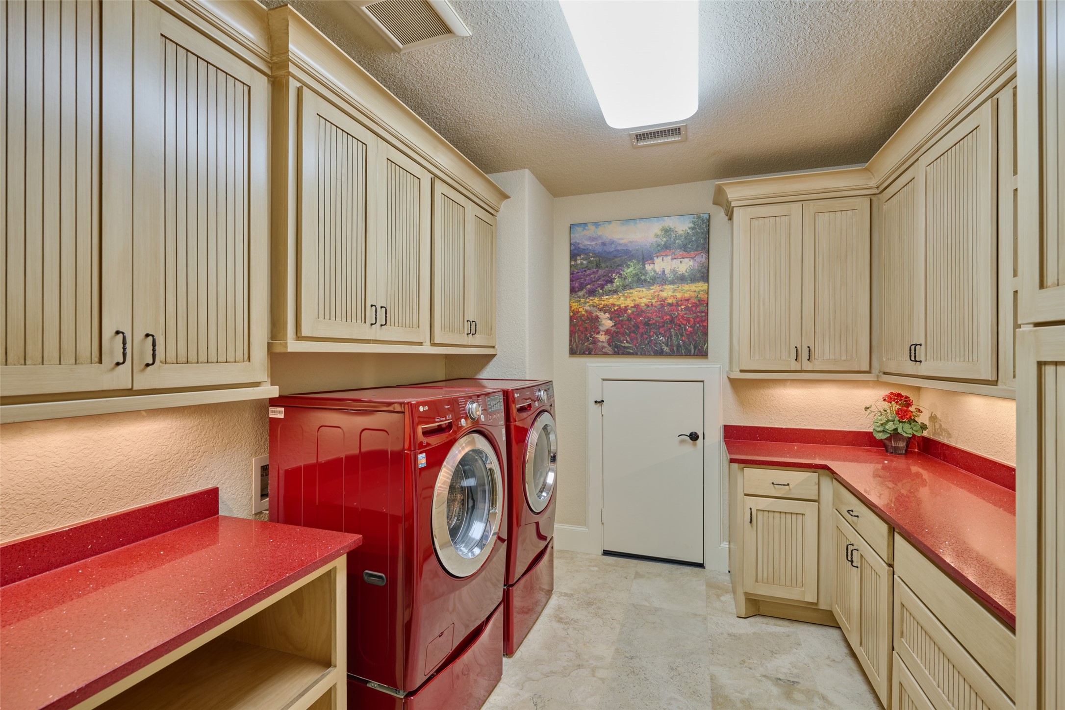 The three bedrooms upstairs have their own full size laundry room, red sparkling granite counters for plenty of folding space, lots of storage cabinets, and an attic access door, polished travertine marble floors, red washer/dryer, on pedastols, barely used, included in sale.