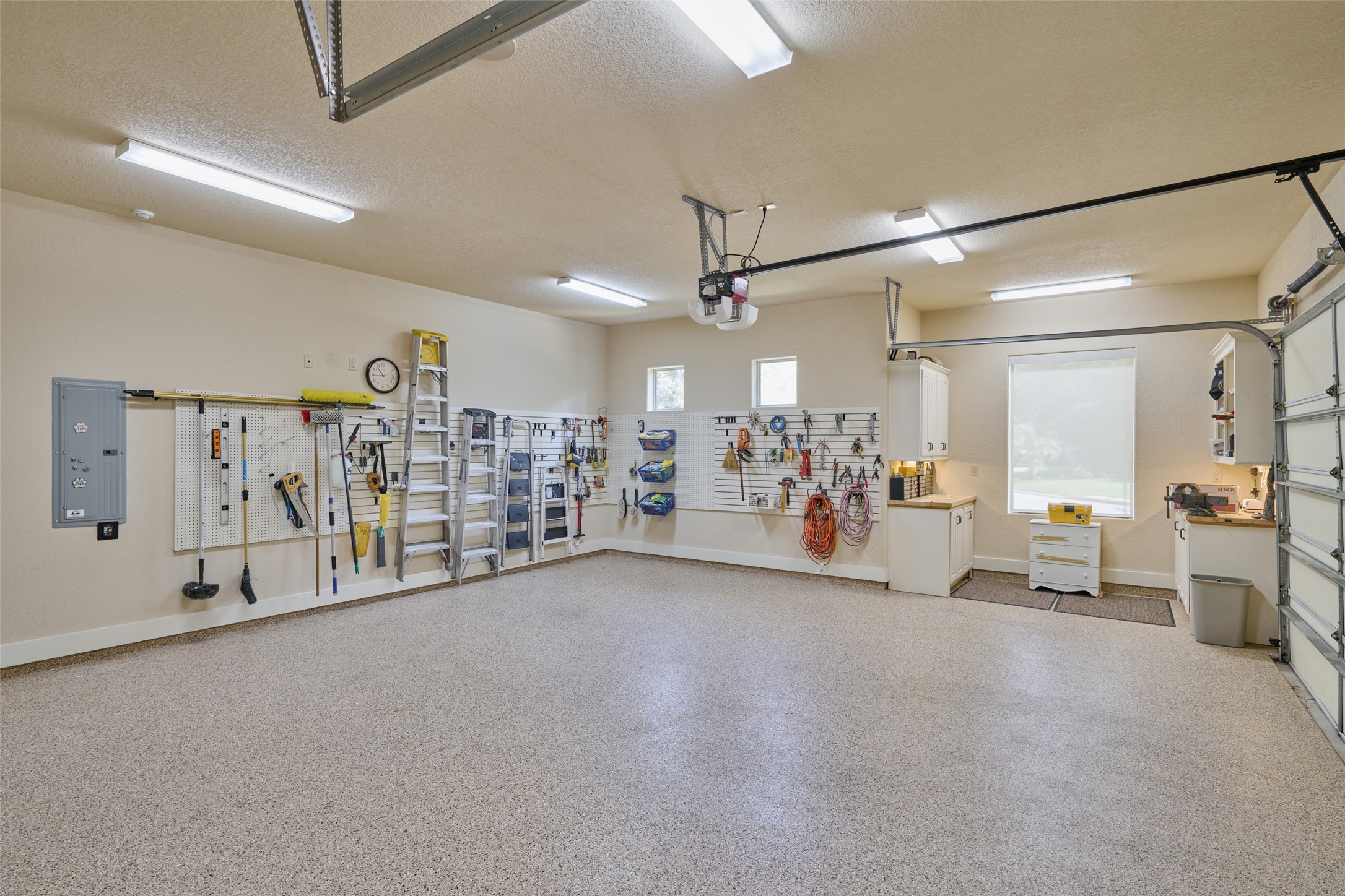The 2 1/2 car garage (different view) is meticulously maintained and organized, epoxy-coated, butcher-block counters, additional workshop area, pegboards, and more!  On the opposite 2-car garage, you can take the stairs up inside the home and land near the Christmas closet!