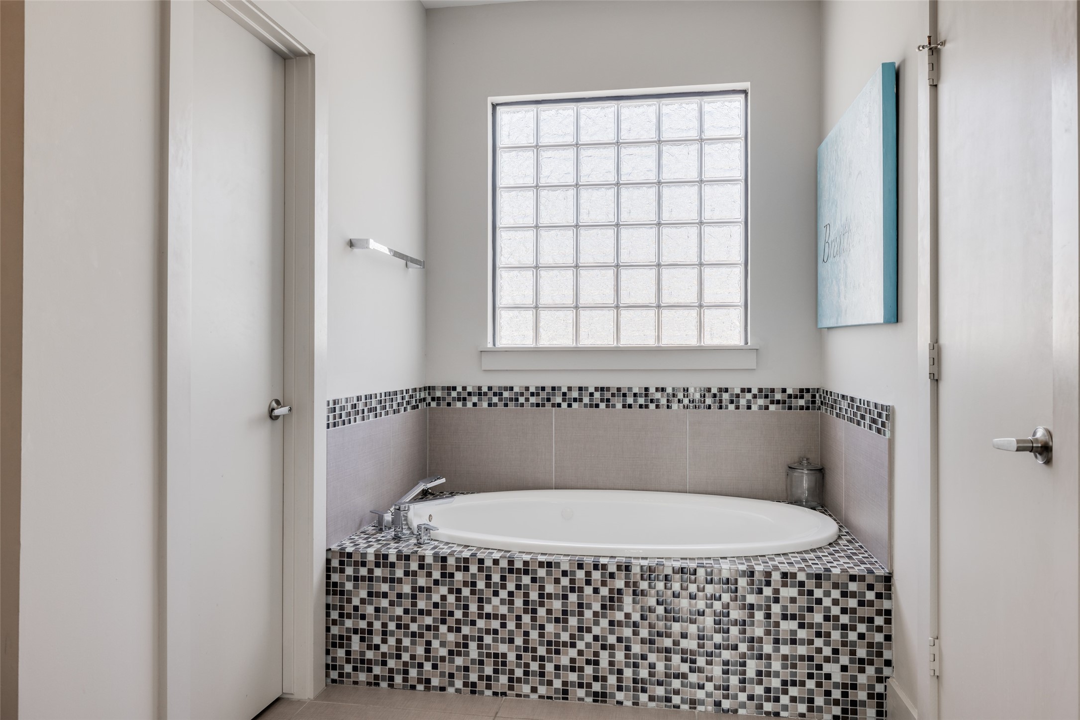 Luxurious Primary Bathroom with large soaking whirlpool tub, separate walk in shower, beautiful Carrera marble counters & mosaic tile bath surround, window gives lots of natural light, 2 separate large closets
