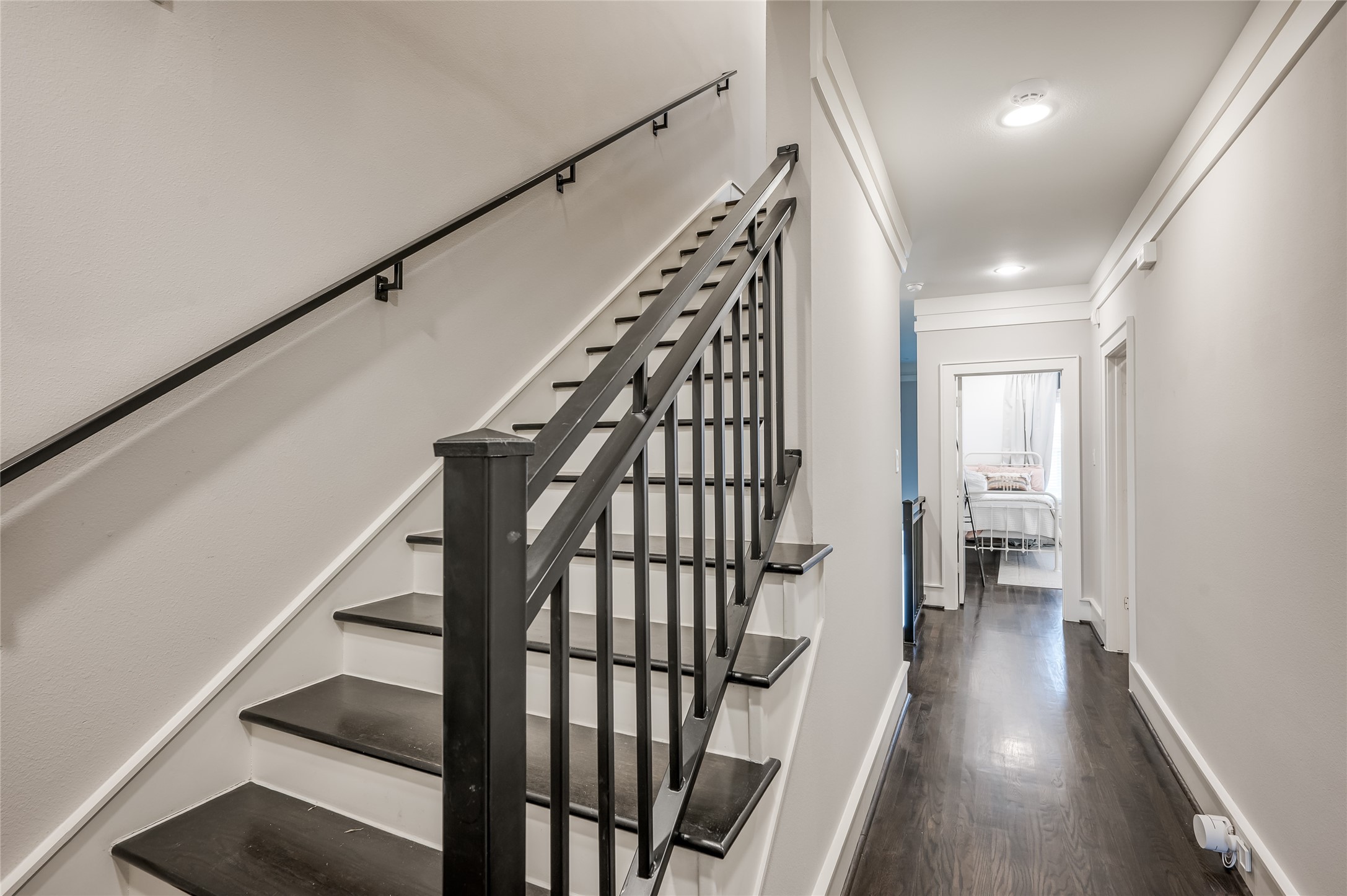 This set of stairs leads to the third floor. Note the handsome metal railing. A neutral palette all around!