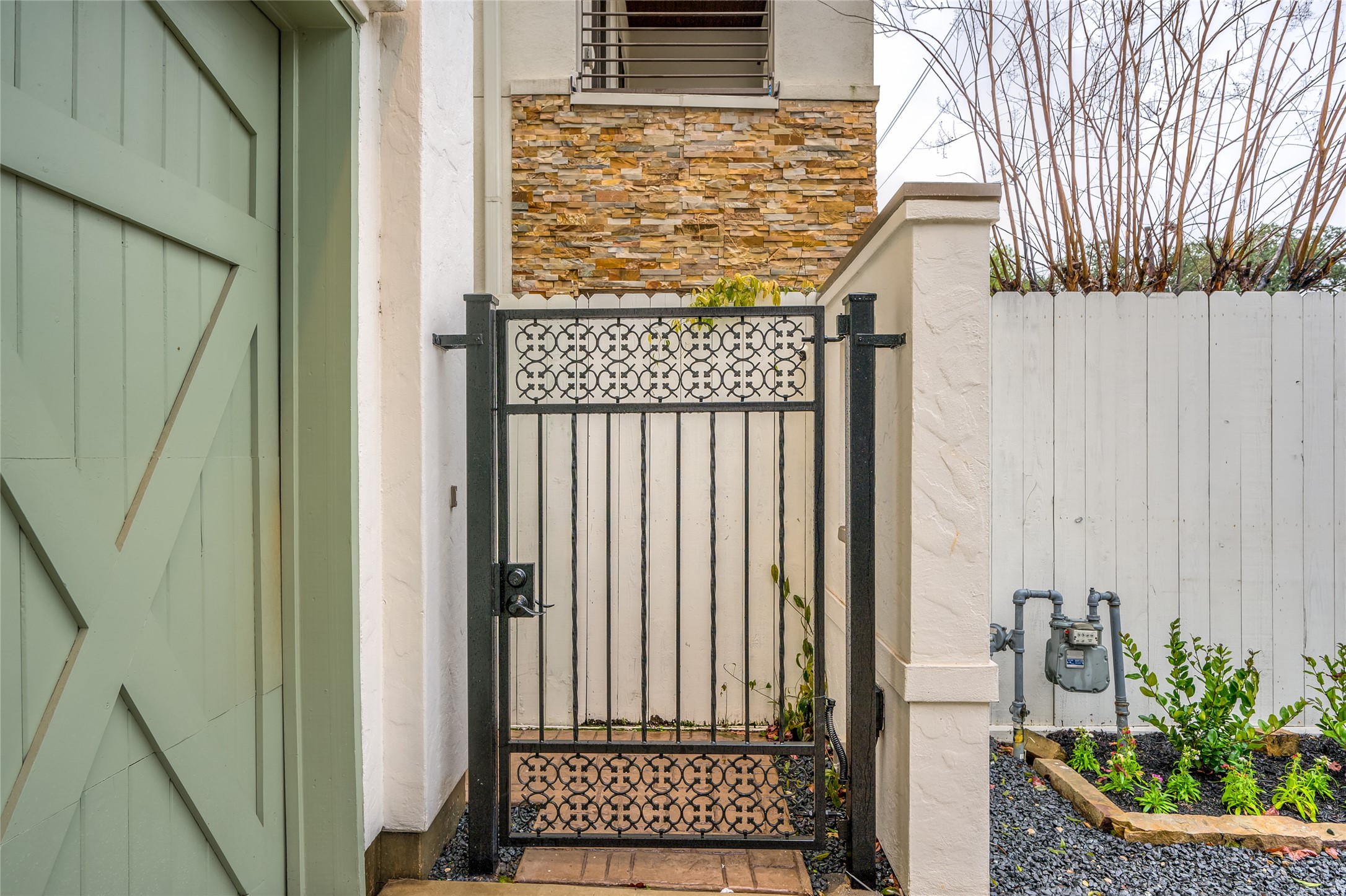 A pretty wrought iron gate & walkway greet you! Fresh landscaping & seasonal color adorn the perimeter of the home.