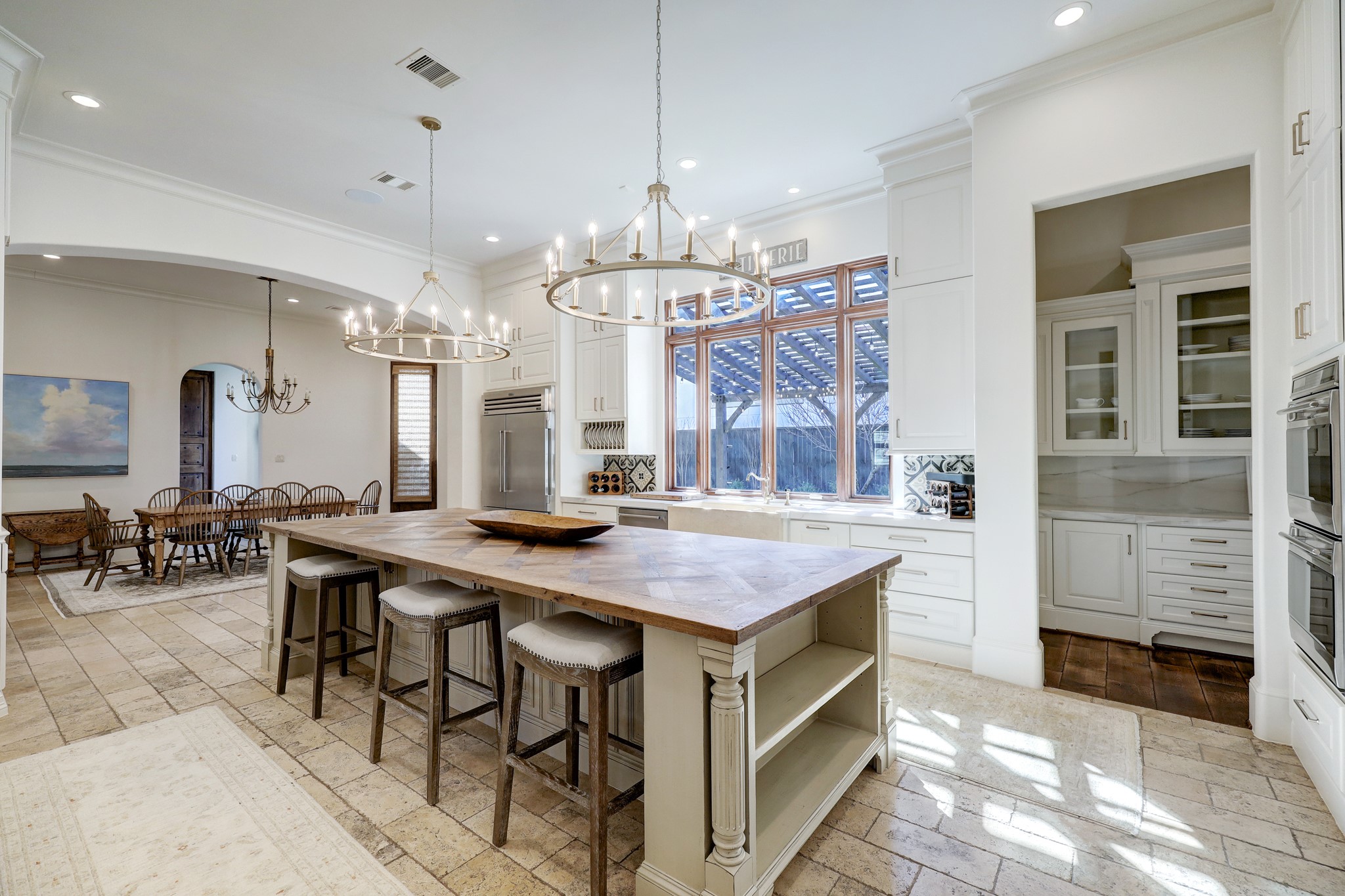 The kitchen is equipped with several impressive features that enhance its functionality and aesthetics. Some notable features include: 6-burner gas range, a walk-in pantry, custom cabinetry, porcelain countertops, double-ovens, and limestone flooring.