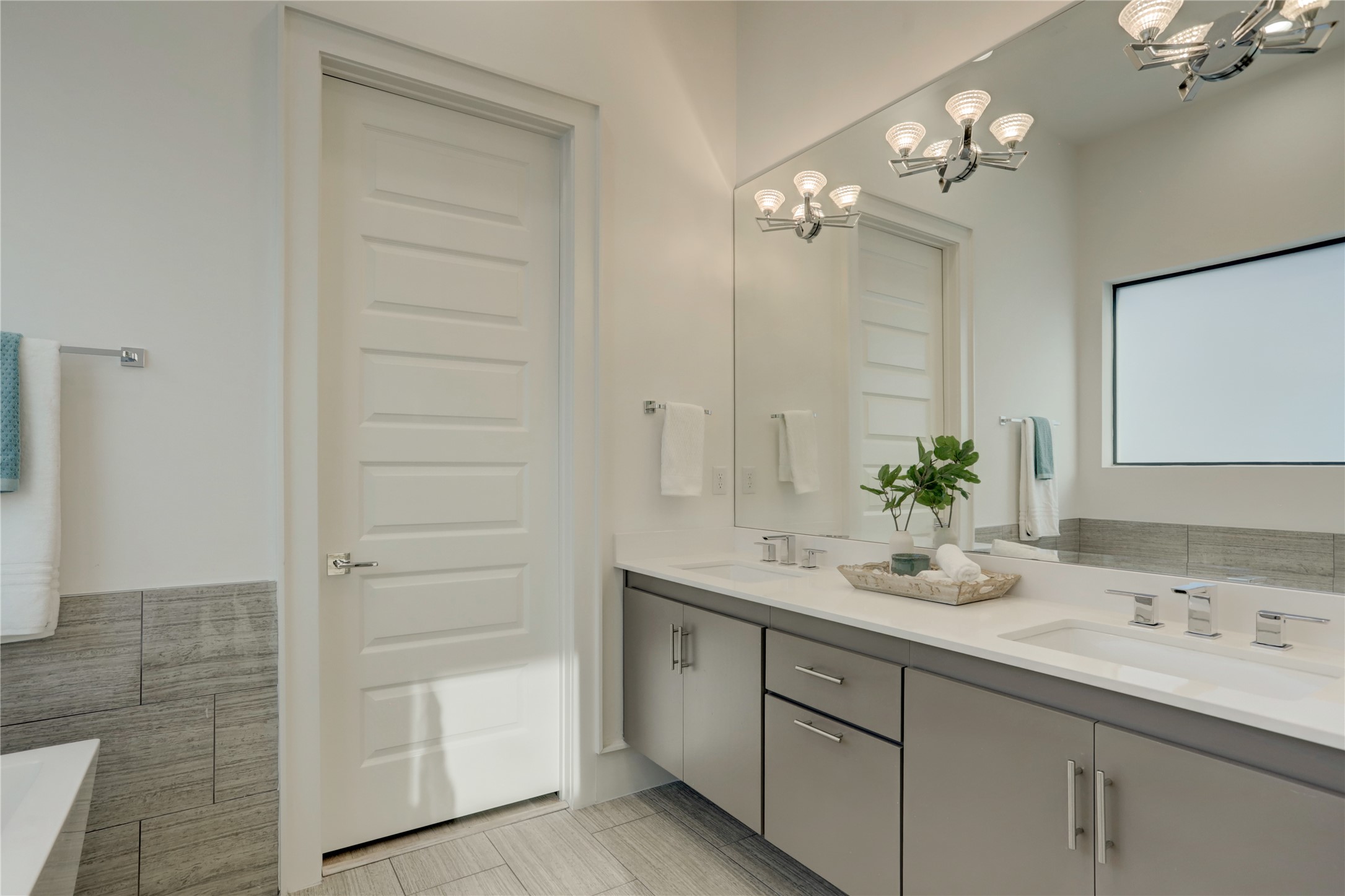 The dual vanities offer ample storage and additional lighting.