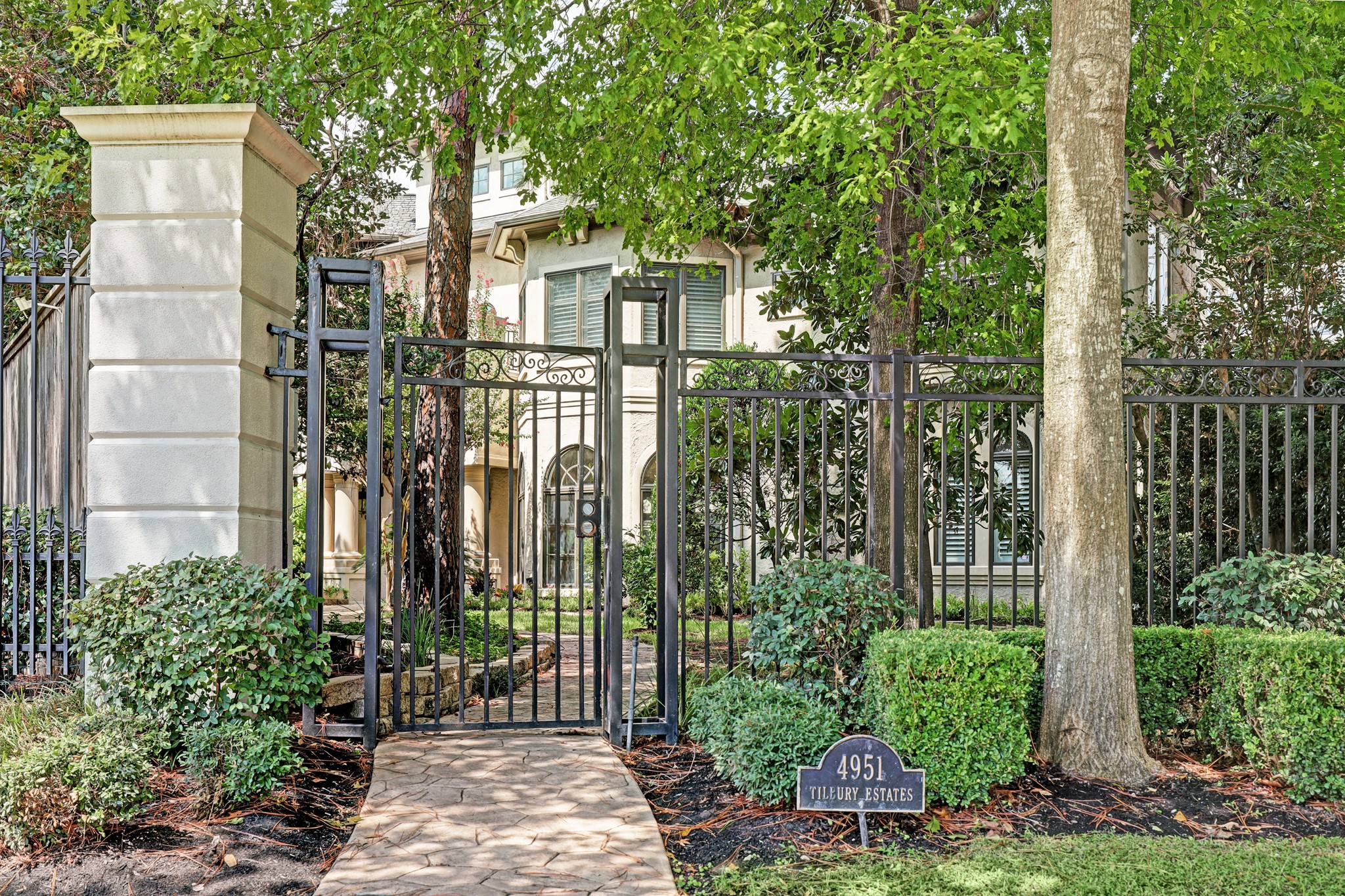 From the front gate at the street, there is a sense of peace and privacy entering into the wooded, lushly landscaped front garden area.