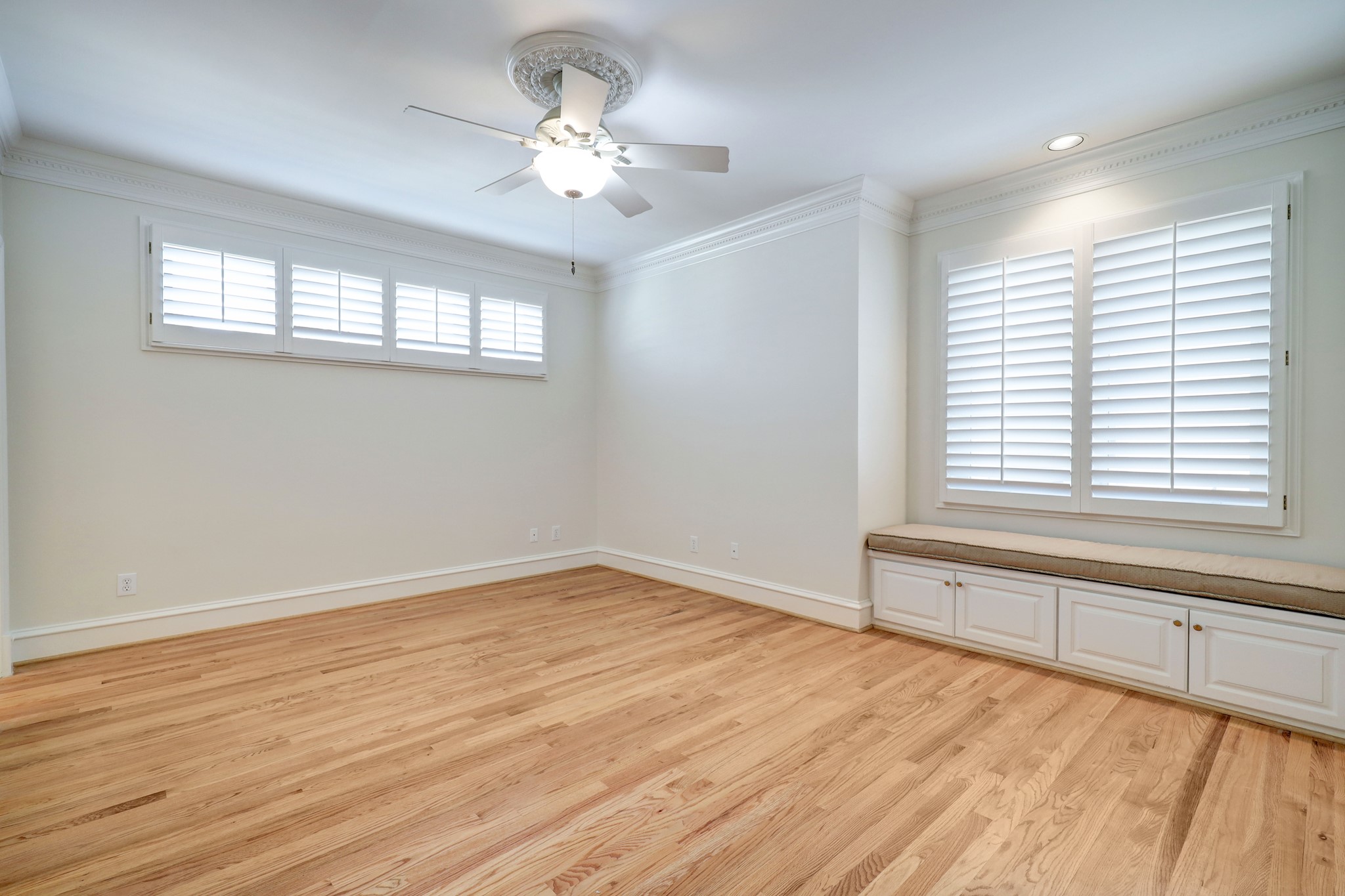 Across the hall from Bedroom 3 is this, Bedroom 4.  Much like the other secondary bedrooms, it features the hardwood flooring, great closet space, plantation shutters, and pretty millwork.  This room's specialty is it's cozy window seating with storage below.