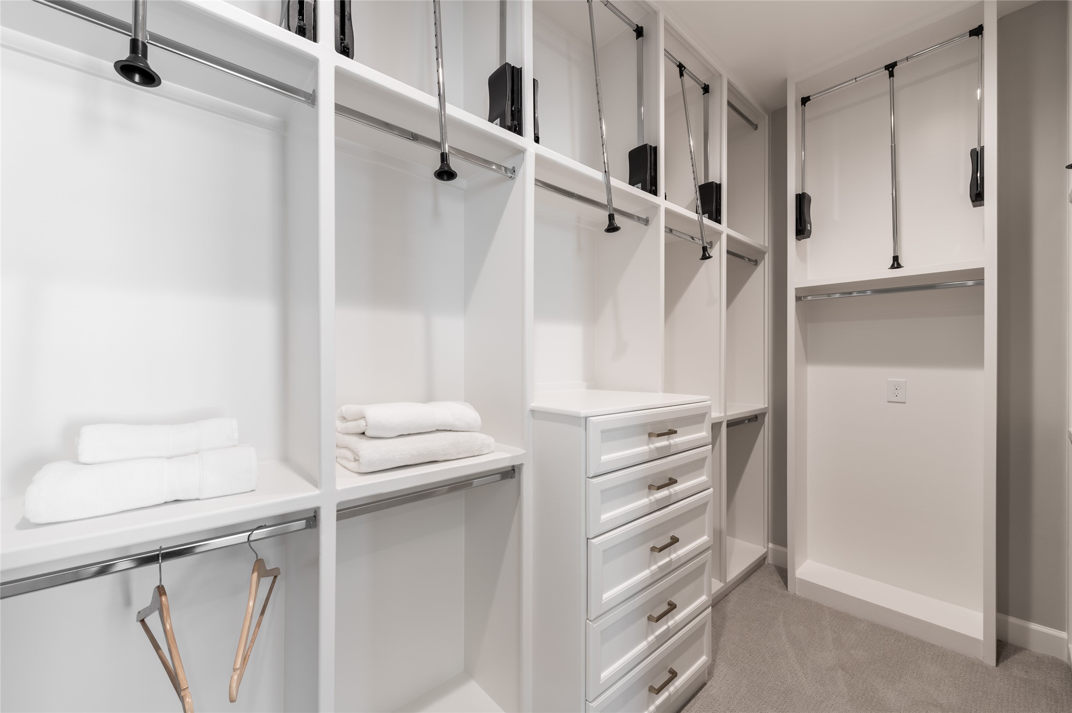 Walk-in closet has custom built-ins and
pull-down rods for easy access and
organization.