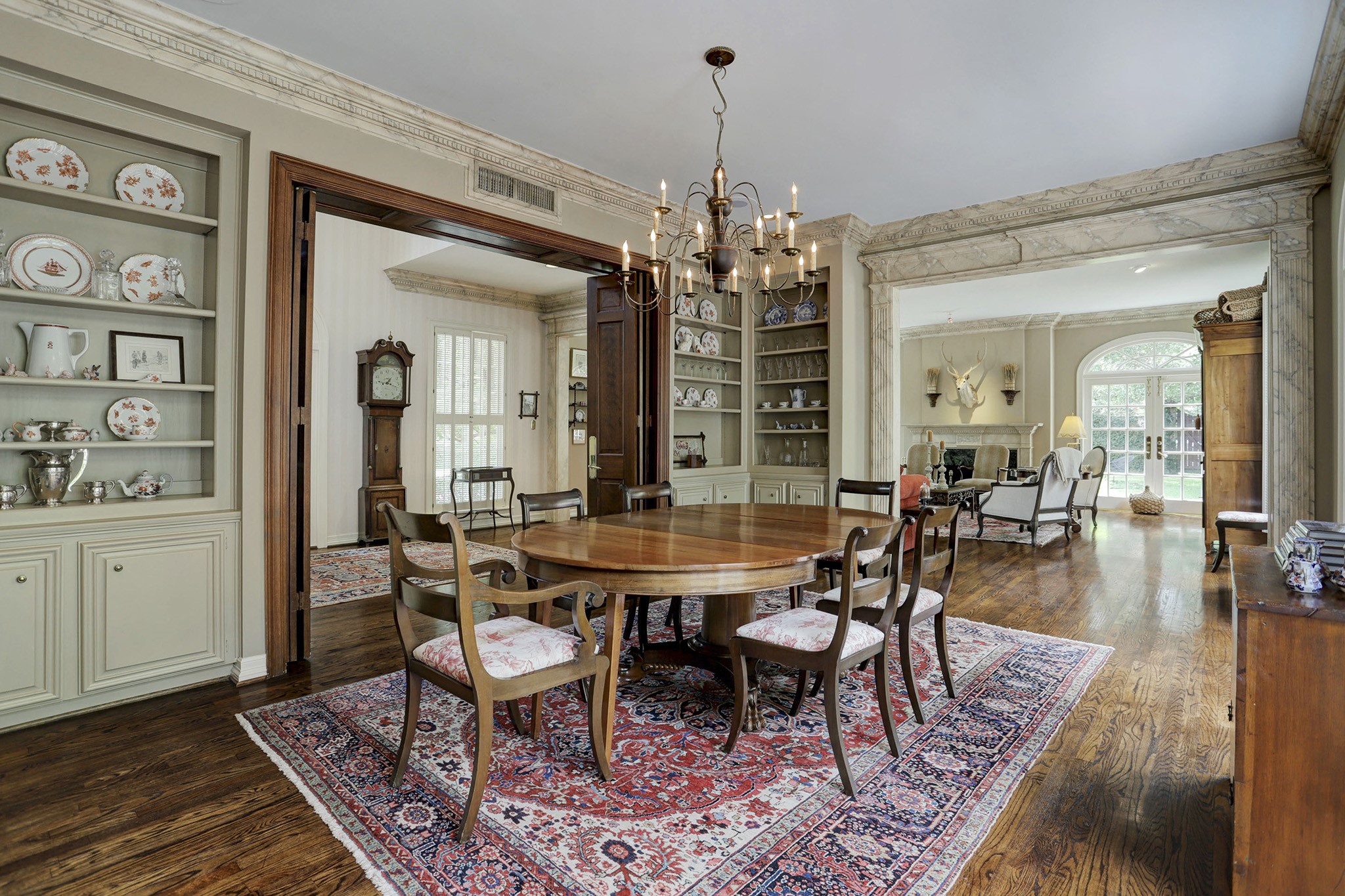 Perfect for small or larger gatherings, the dining room has built-in shelves and cabinets, hardwood floors and French doors that open to the inviting brick patio and outdoor kitchen.