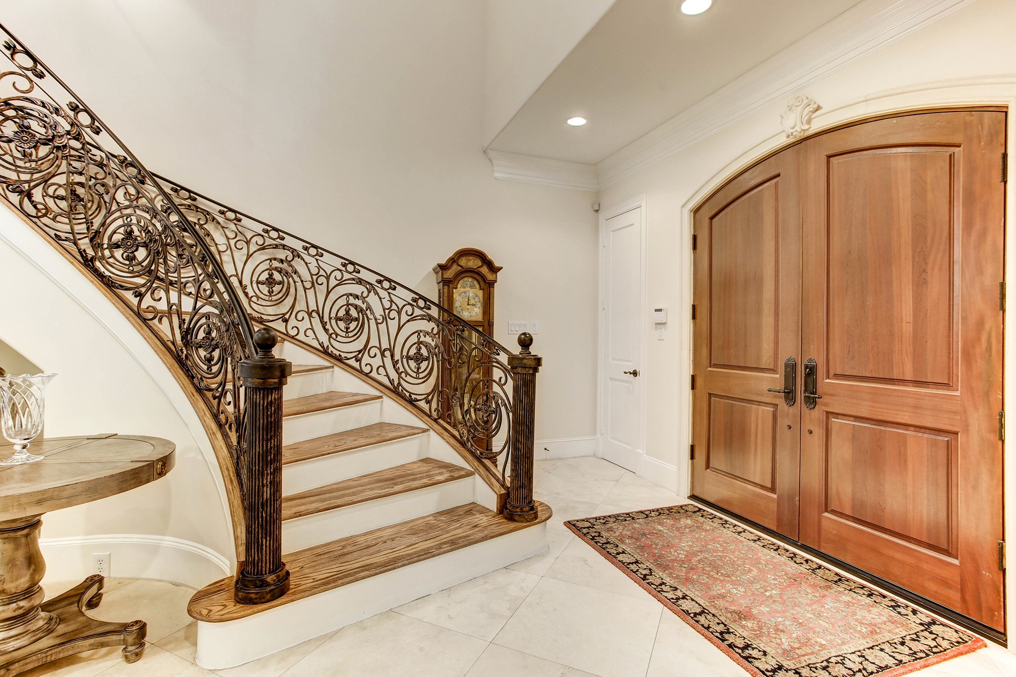 The sweeping staircase has decorative iron banister with wood steps leading to the 2nd floor landing with hardwood floors.  The entrance has travertine marble.