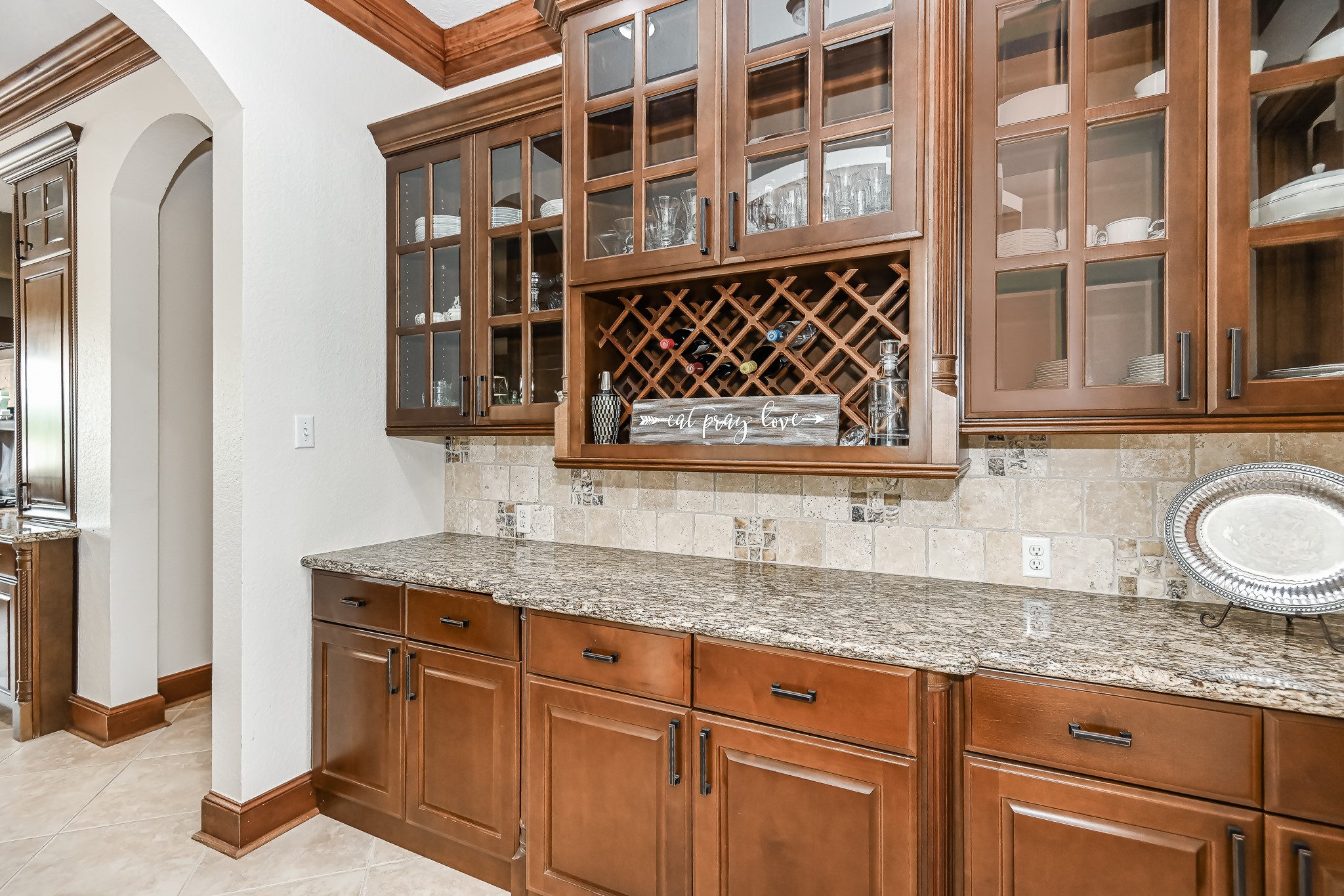 Butler's pantry with glass cabinet doors and wine storage.