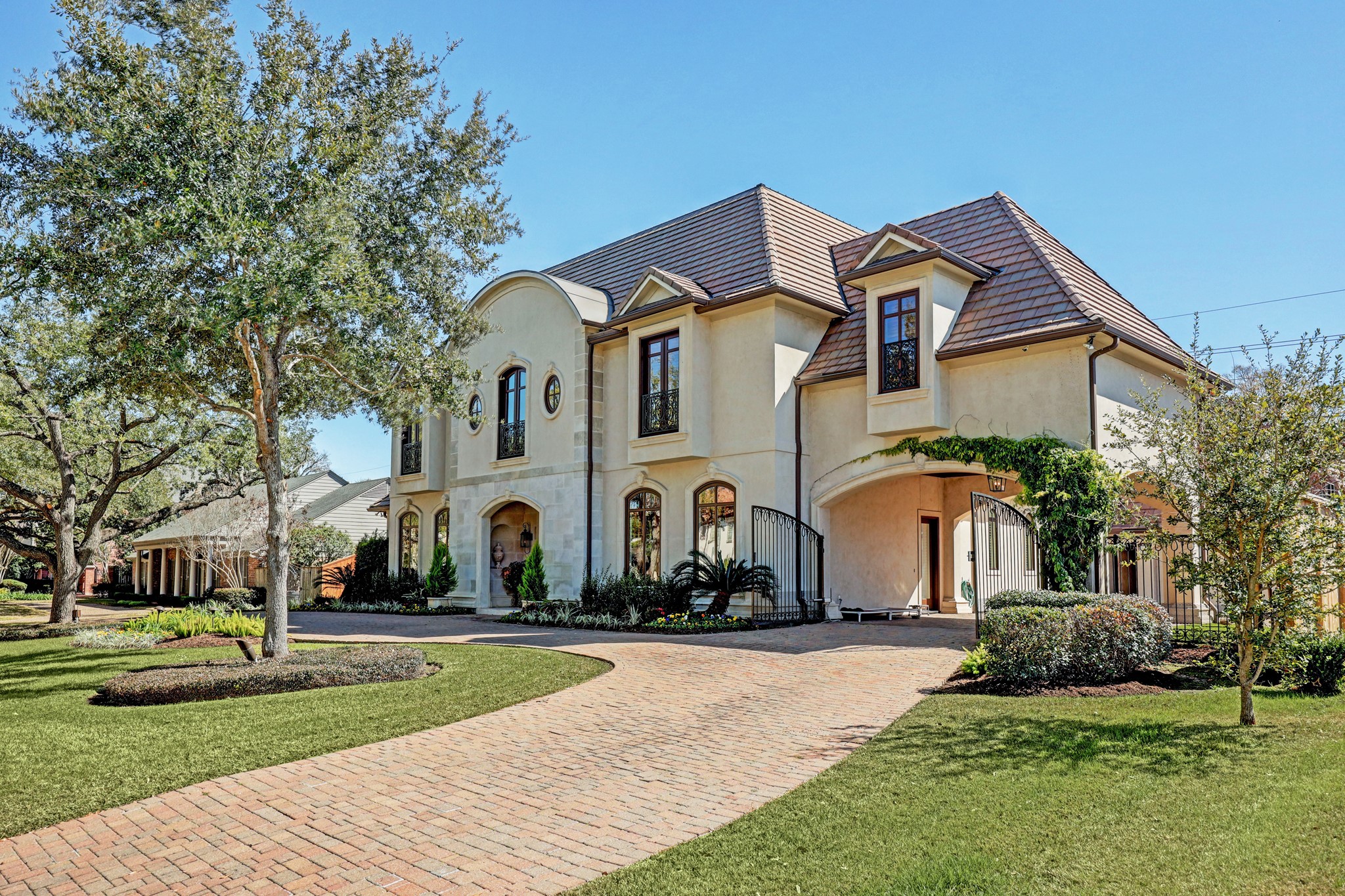A circular drive, gated porte-cochère and four-car garage provide abundant parking in this gorgeous Tanglewood showplace.