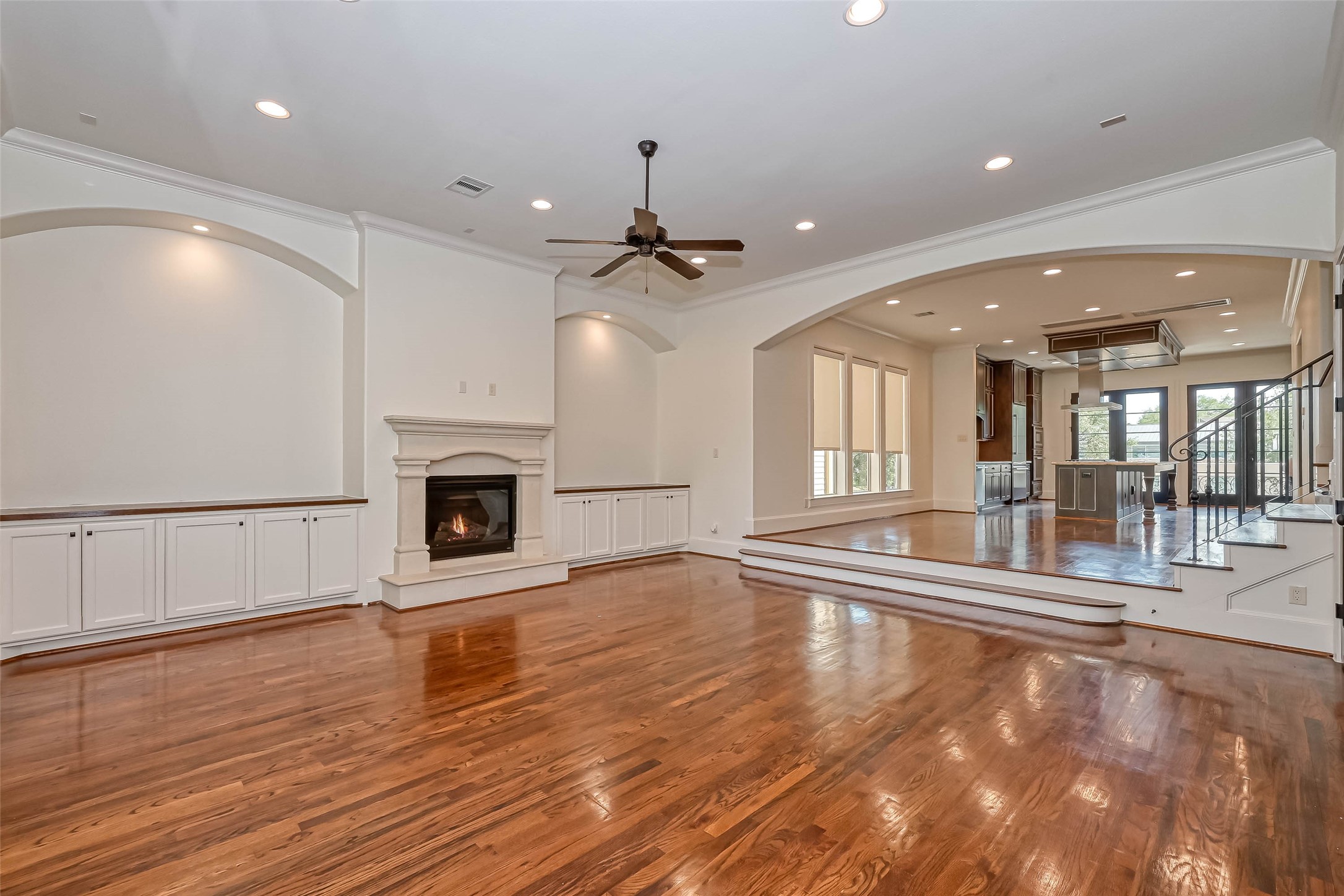 Overview of the living room featuring wood flooring and a remote control fireplace
