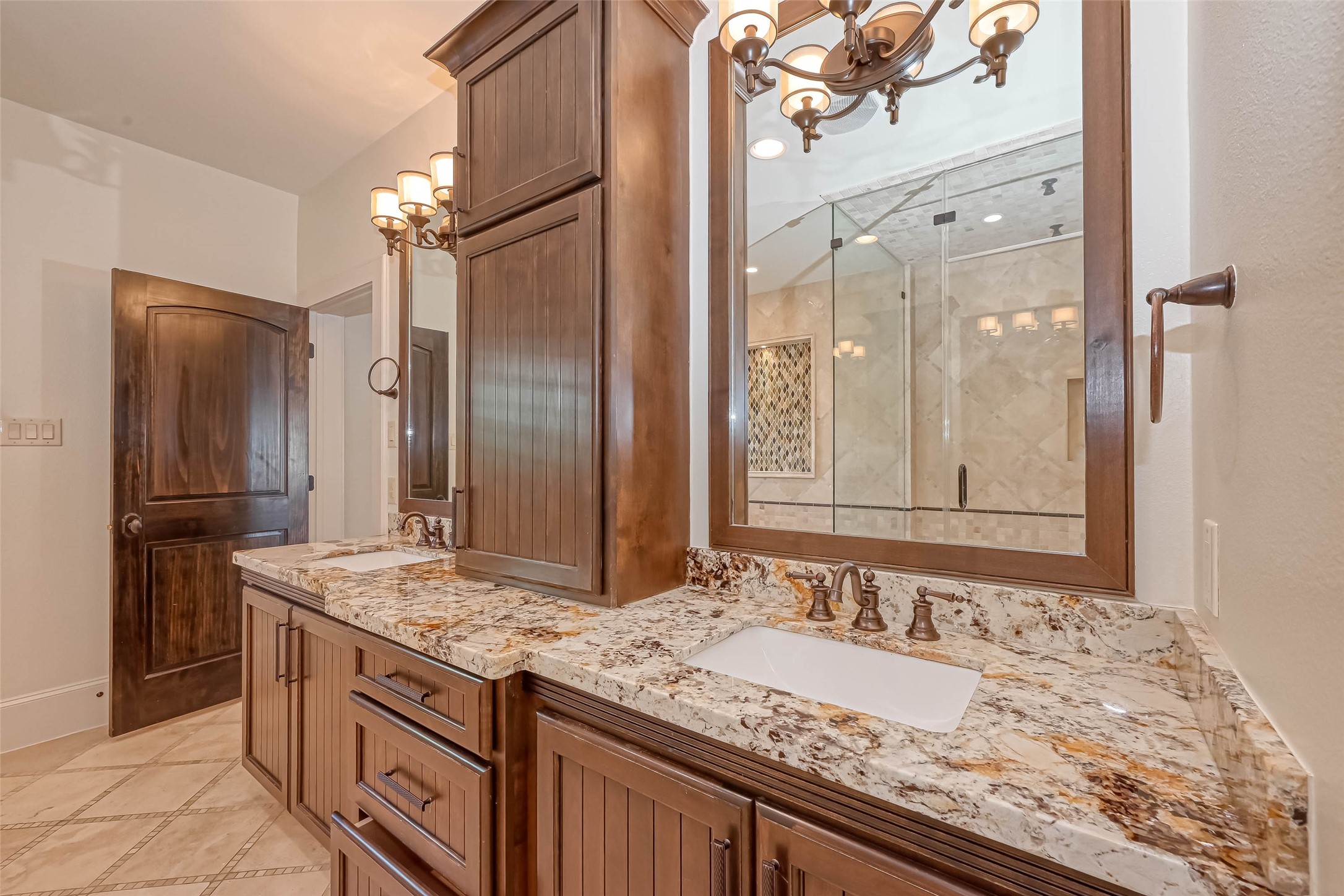 Primary bath with double sinks, granite counters and a storage tower