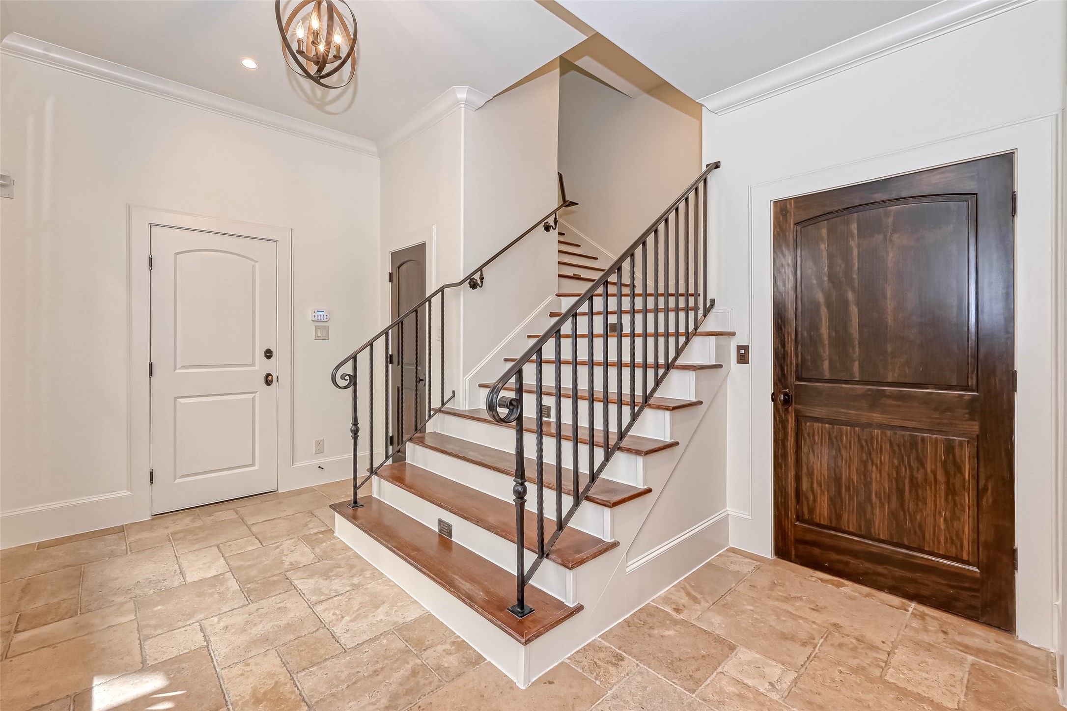 Entry with tile flooring, brown door is the featured elevator for this home. Note the stairs have lighting on the steps for safety and a pretty look.