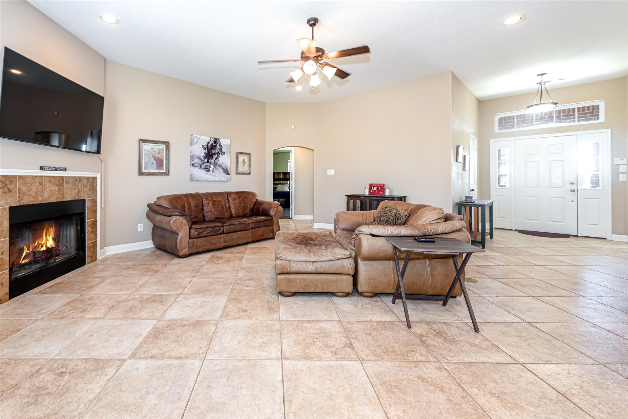 Living area has tile floor and ceiling fan with lights.